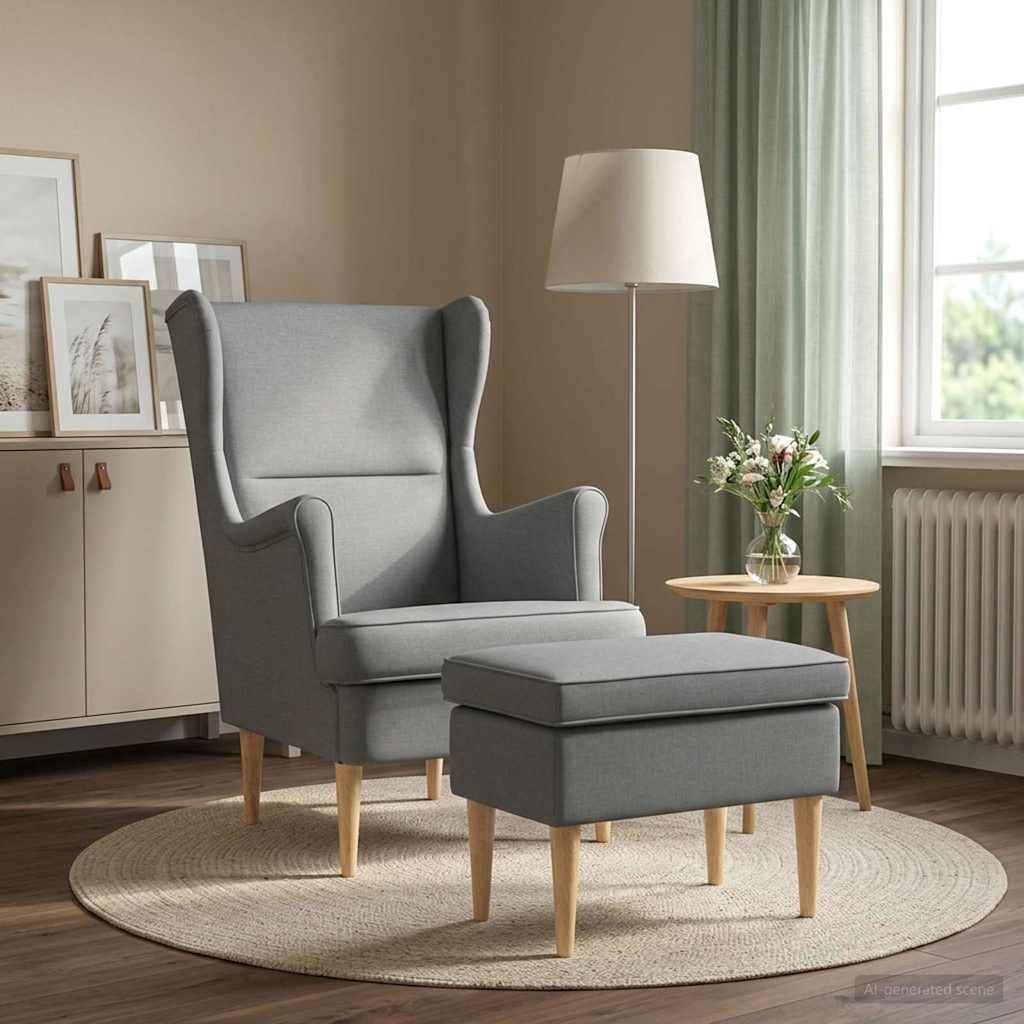Grauer Wingback-Sessel mit passendem Ottomane auf einem runden Teppich neben einer Stehlampe, einem Beistelltisch und einem Fenster in einem ruhigen Wohnzimmer.