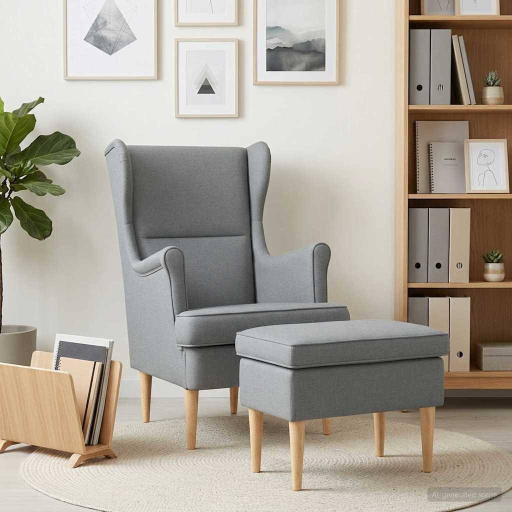 Grauer bezogener Wingback-Sessel mit passendem Hocker in einem hellen Wohnzimmer, neben einem Bücherregal und Wandkunst, auf einem runden Teppich.