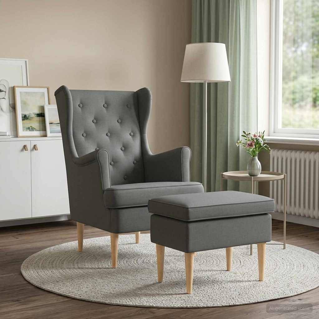 Grauer gepolsterter Ohrensessel mit passendem Fußhocker auf einem runden Teppich in einem hellen Wohnzimmer neben einem Fenster, eine Lampe und ein Beistelltisch in der Nähe.