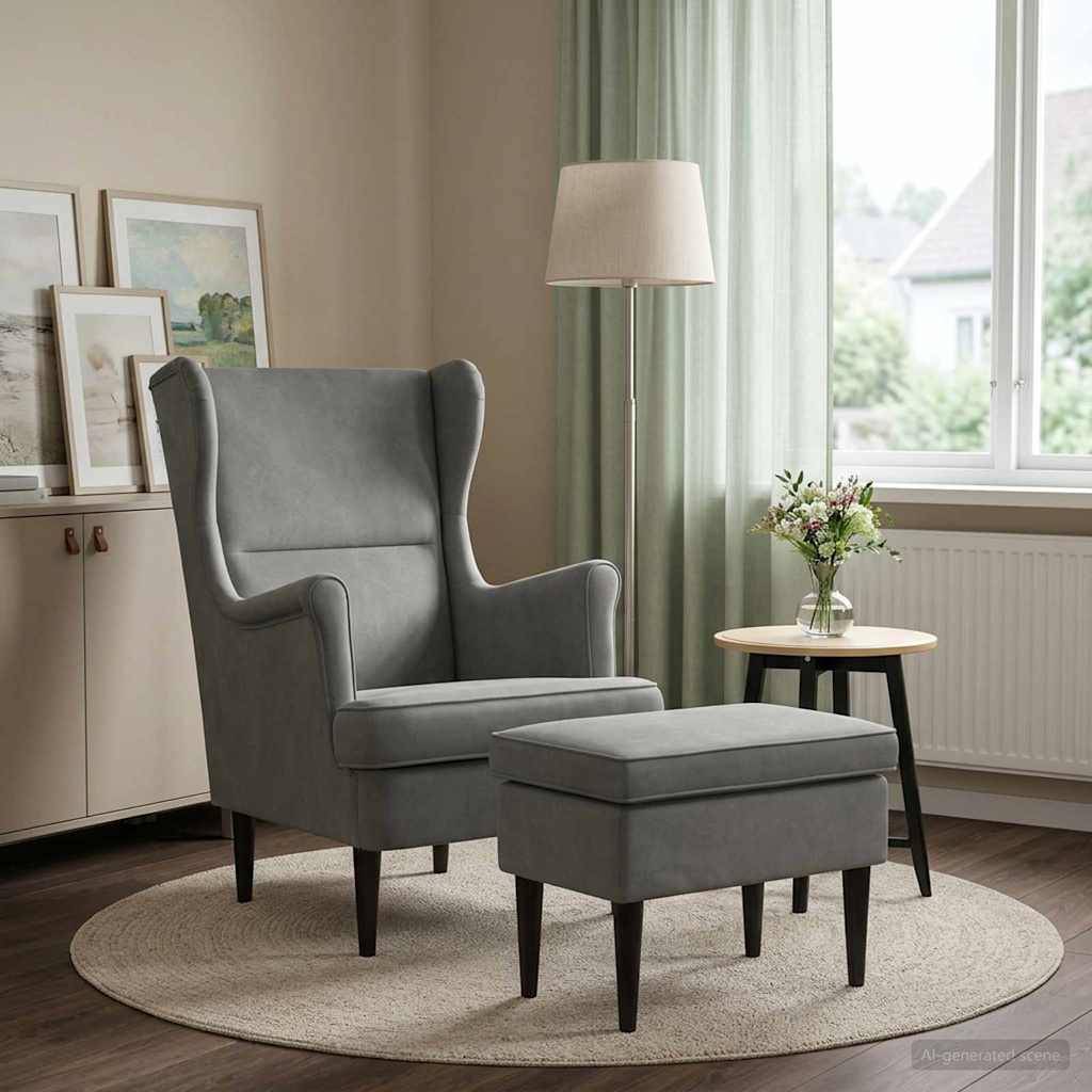 Grauer Flügelsessel mit passendem Polsterhocker auf einem runden Teppich neben einem Beistelltisch und einer Lampe in einem hellen Wohnzimmer.