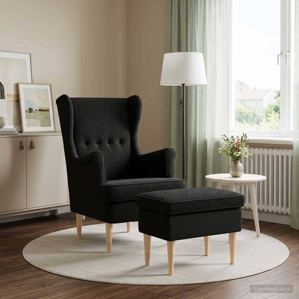 Schwarzer Ohrensessel mit passendem Fußhocker in einem hellen Wohnzimmer neben einem Beistelltisch, einer Lampe und einem Fenster.