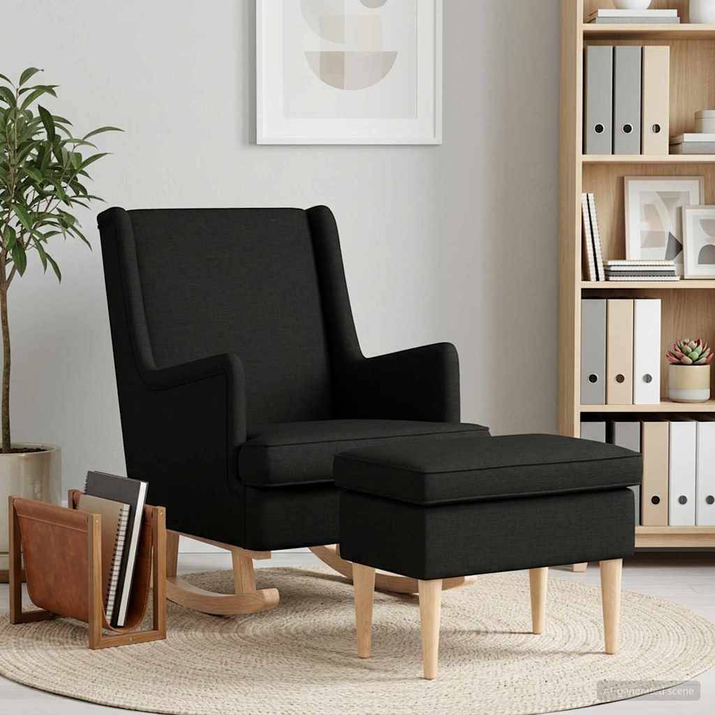 Schwarzer gepolsterter Sessel mit passendem Fußhocker auf einem runden Teppich in einem modernen Wohnzimmer mit Bücherregal und Topfpflanze.