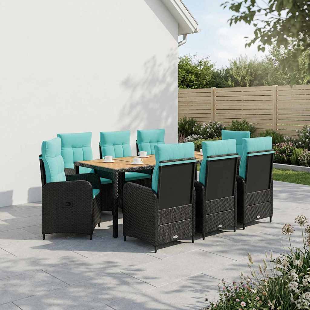 Esszimmer-Set für die Terrasse im Freien mit acht schwarzen Korbstühlen und blaugrünen Kissen um einen Holztisch neben einer weißen Wand und einem Gartenzaun.