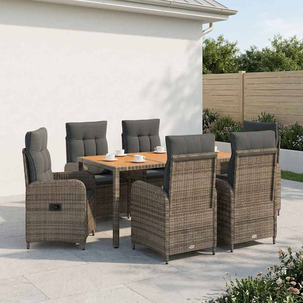 Esszimmer-Set für die Terrasse mit sechs Korbsesseln um einen quadratischen Tisch auf einer Steinterrasse neben einem weißen Haus und einem Gartenzaun.
