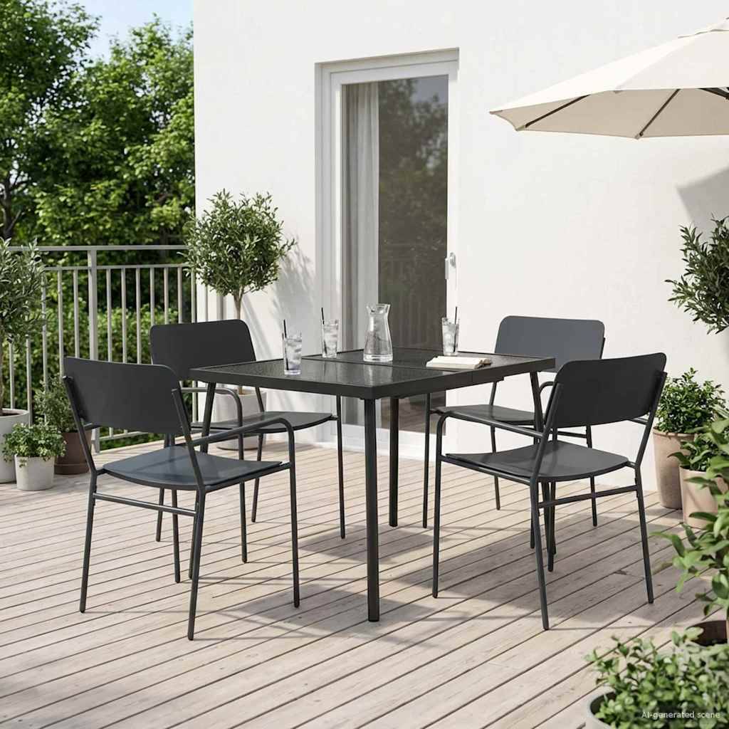 Gartenmöbelset für die Terrasse mit vier schwarzen Stühlen um einen quadratischen Tisch auf einer Holzterrasse neben einem weißen Haus, mit Sonnenschirm und Pflanzen.