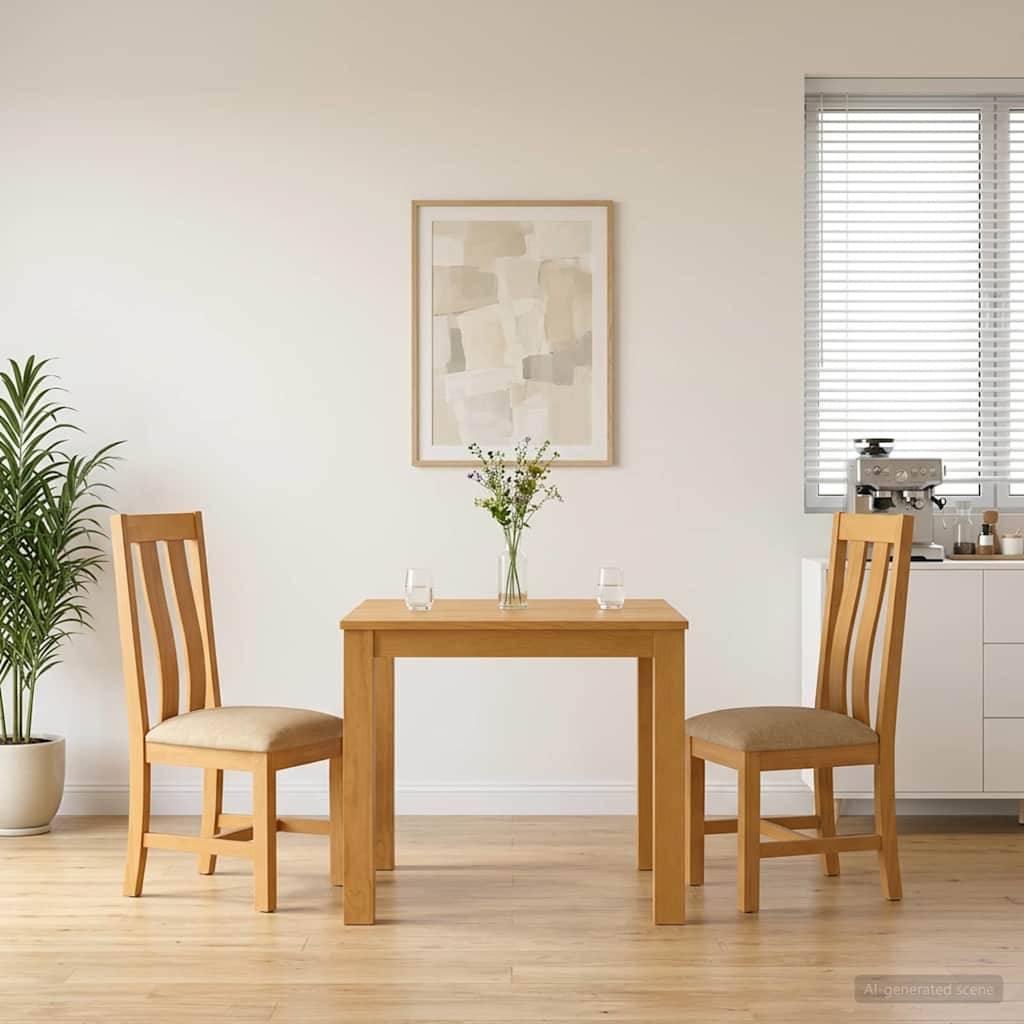 Eine einfache Essnische mit zwei Holzstühlen, die sich einem kleinen Tisch gegenüber befinden, eine Vase mit Blumen, Wandkunst und ein Fenster in einem hellen, minimalistischen Raum.