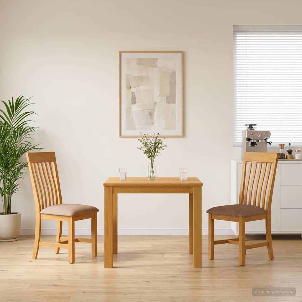 Minimalistischer Essbereich mit zwei Holzstühlen, einem kleinen Tisch, einer Vase mit Blumen, gerahmten Wandbildern und einer Topfpflanze neben einem Fenster.