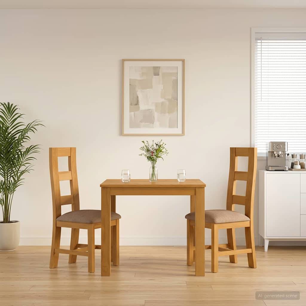 Minimalistische Essecke mit zwei Holzstühlen und einem kleinen Tisch, auf dem Blumen und Gläser stehen, an einer weißen Wand mit Bilderrahmen, neben einer Pflanze und einem Fenster.