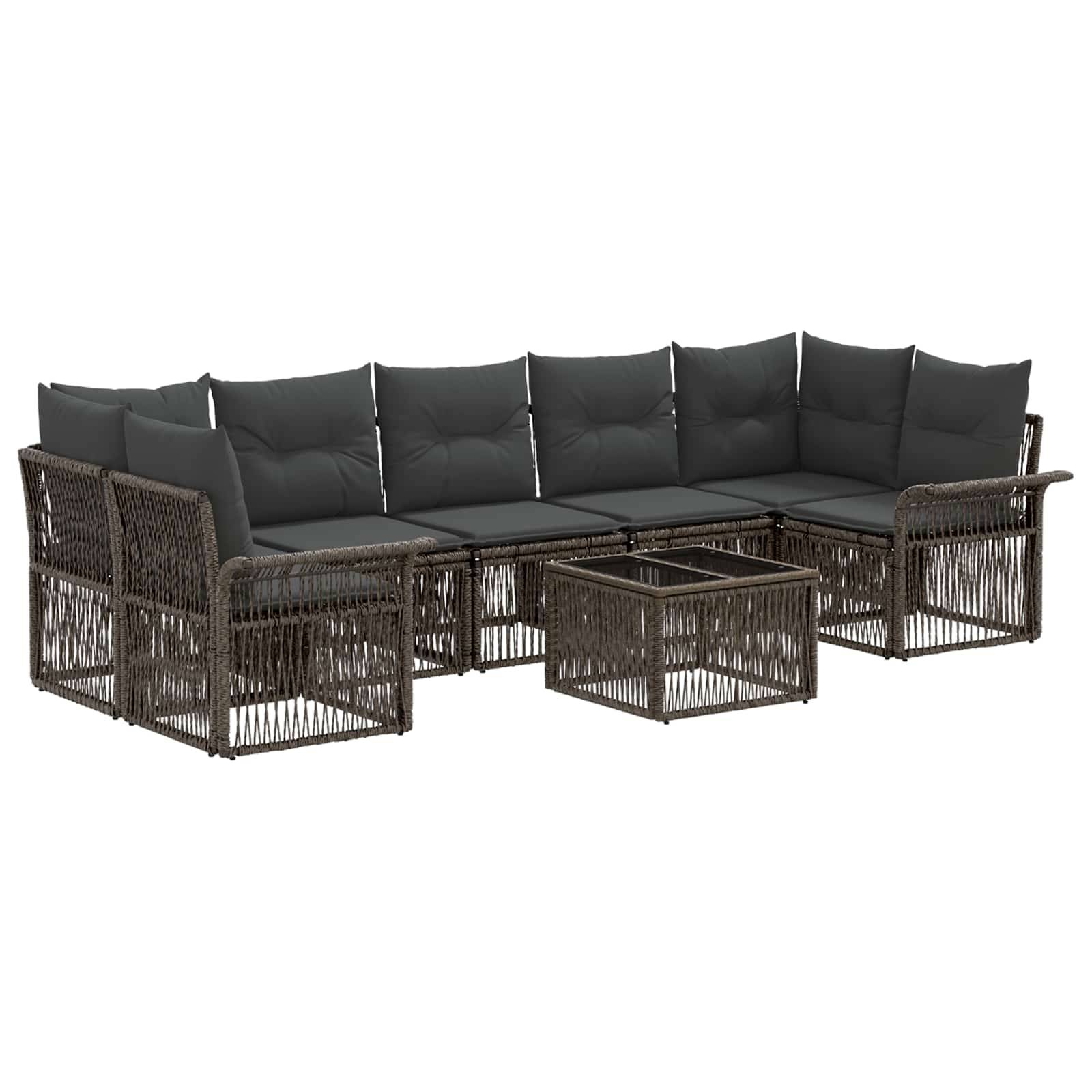 Outdoor-Rattan-Loungeset mit dunklen Kissen und passendem Glastisch auf weißem Hintergrund.