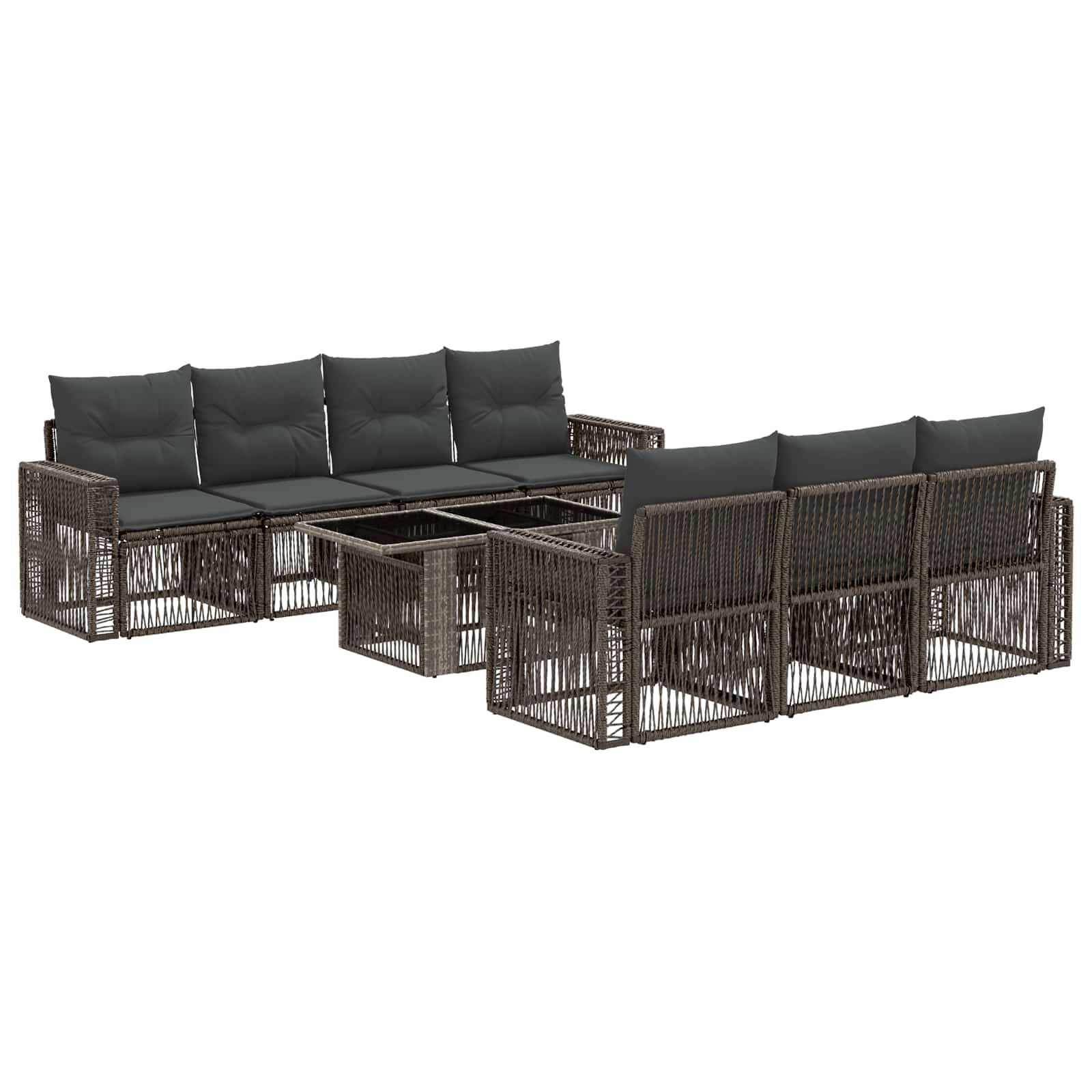 Braune Rattanlounge-Garnitur im Freien mit dunklen Kissen und zwei passenden Couchtischen auf weißem Hintergrund.
