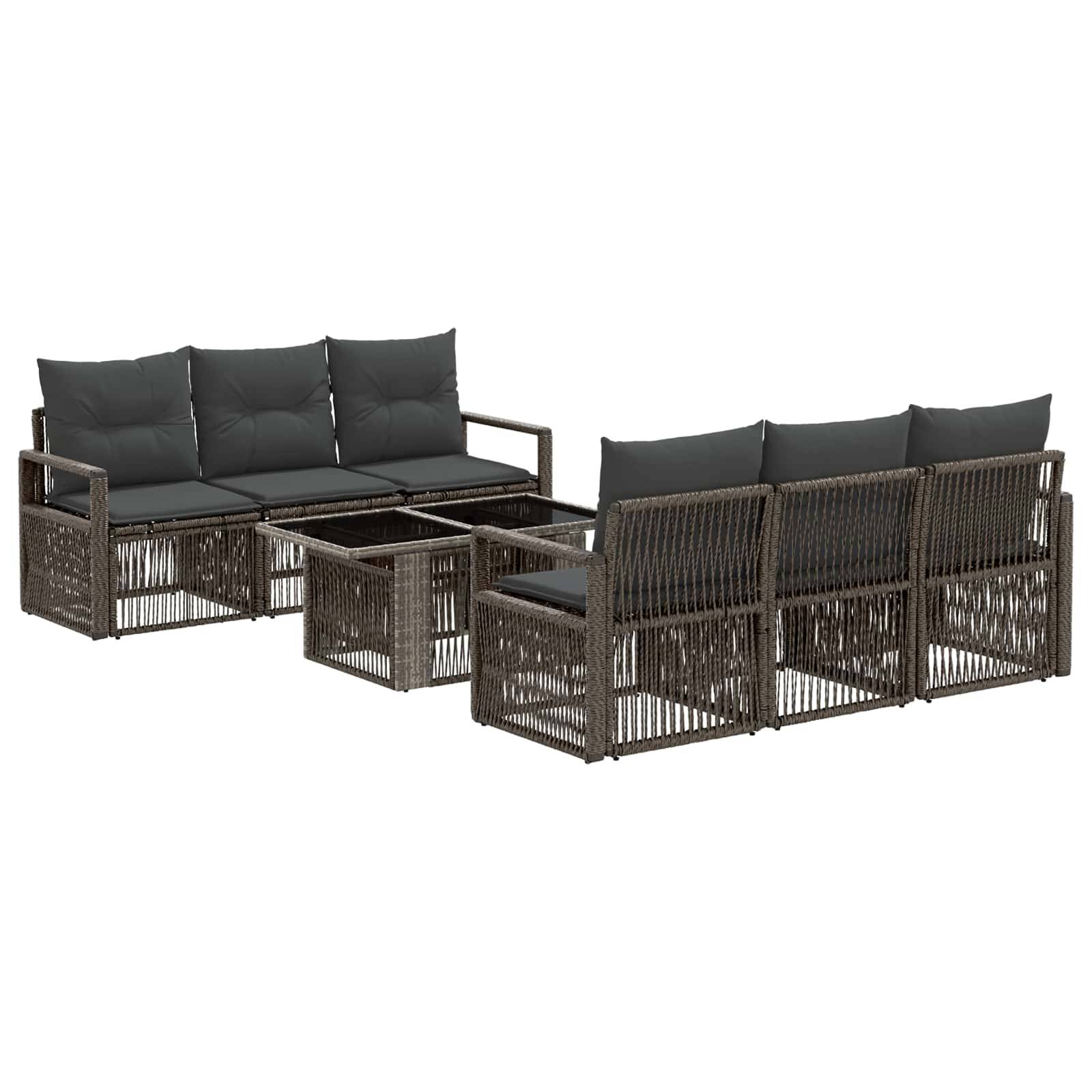 Zwei dunkle Rattan-Außensofas mit schwarzen Kissen, angeordnet um zwei quadratische Couchtische auf weißem Hintergrund.
