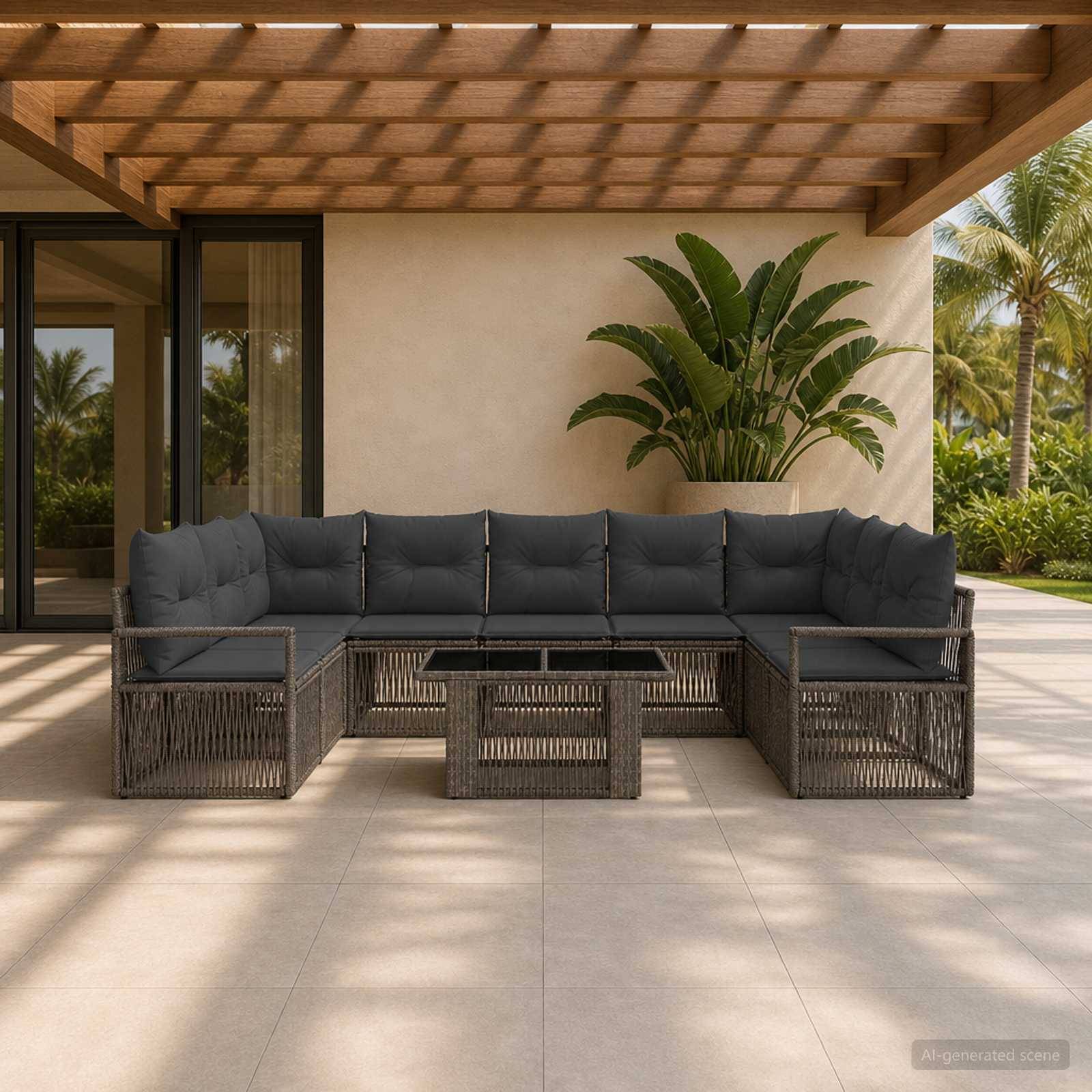 Terrasse im Freien mit einem L-förmigen Flechtsofa, grauen Kissen und einem passenden Couchtisch unter einer Holzpergola neben tropischen Pflanzen.