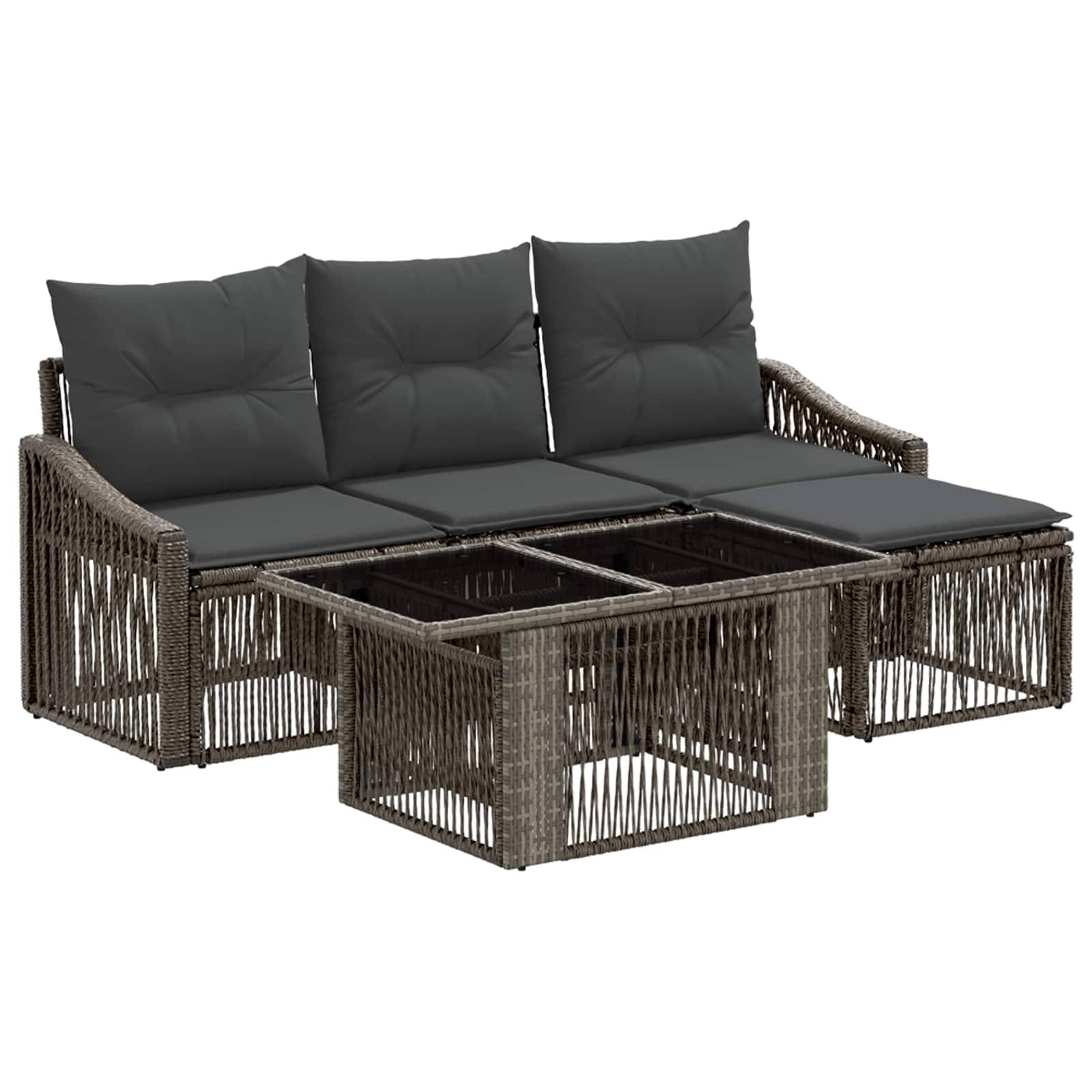 Außen-Rattansofa im Eckformat mit dunklen Kissen und passendem Glastisch auf weißem Hintergrund