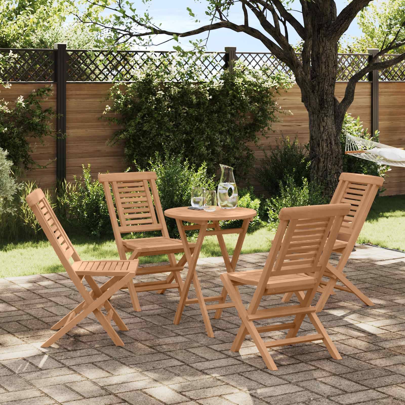 Holzgarnituren für die Terrasse mit vier Klappsesseln um einen runden Tisch mit einer Kanne und Gläsern in einem sonnigen Garten.