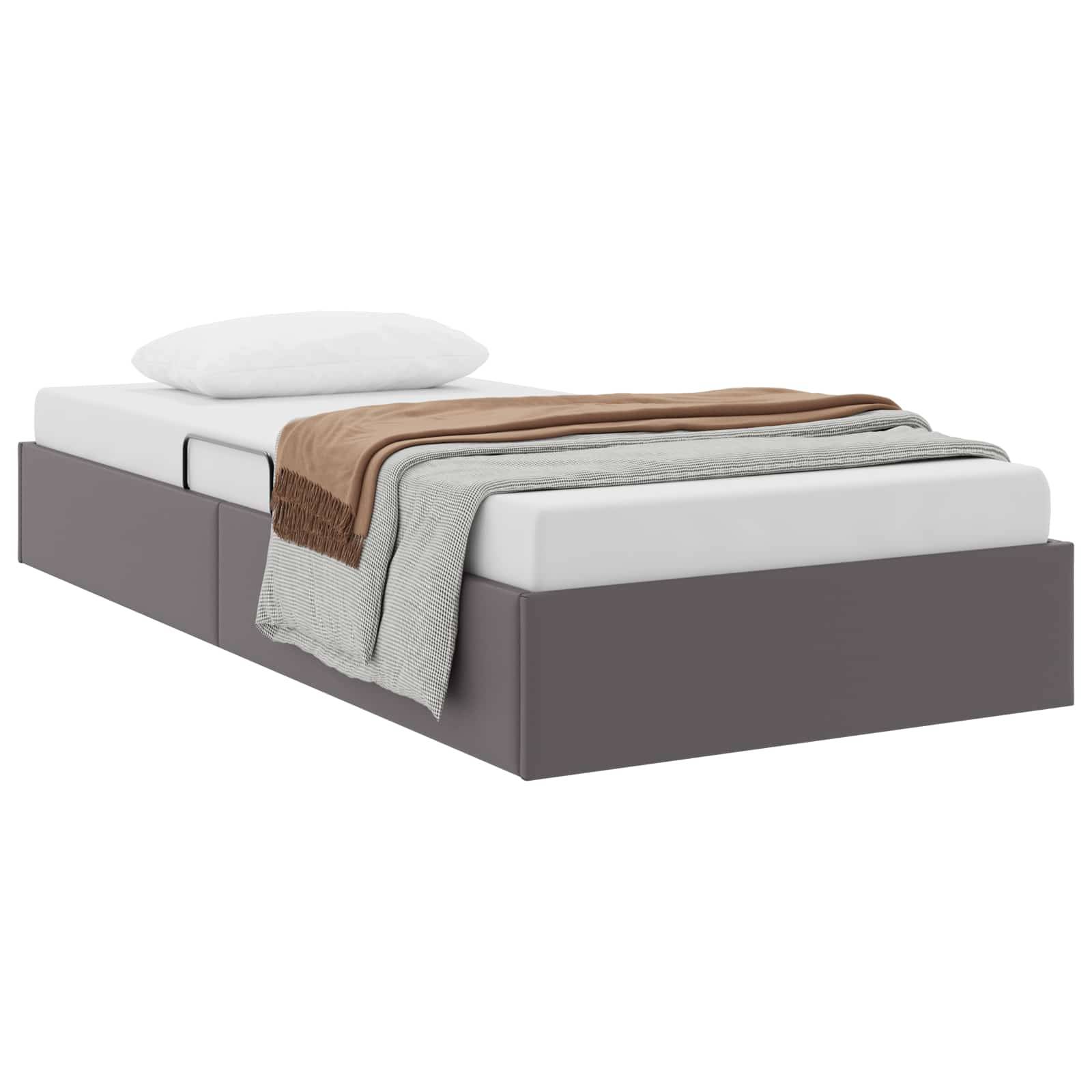 Modernes graugepolstertes Bett mit weißer Matratze, Kissen und gefalteten beige- und graubraun Decken auf weißem Hintergrund.