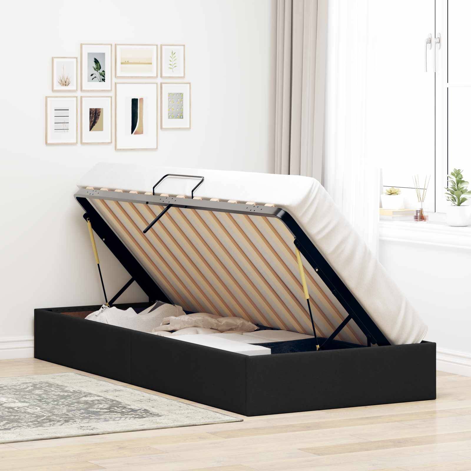 Ein schwarz gepolstertes Bett mit Hydrauliklift-Stauraum ist in einem hellen Schlafzimmer geöffnet und zeigt die Latten und den Stauraum unter dem Bett.