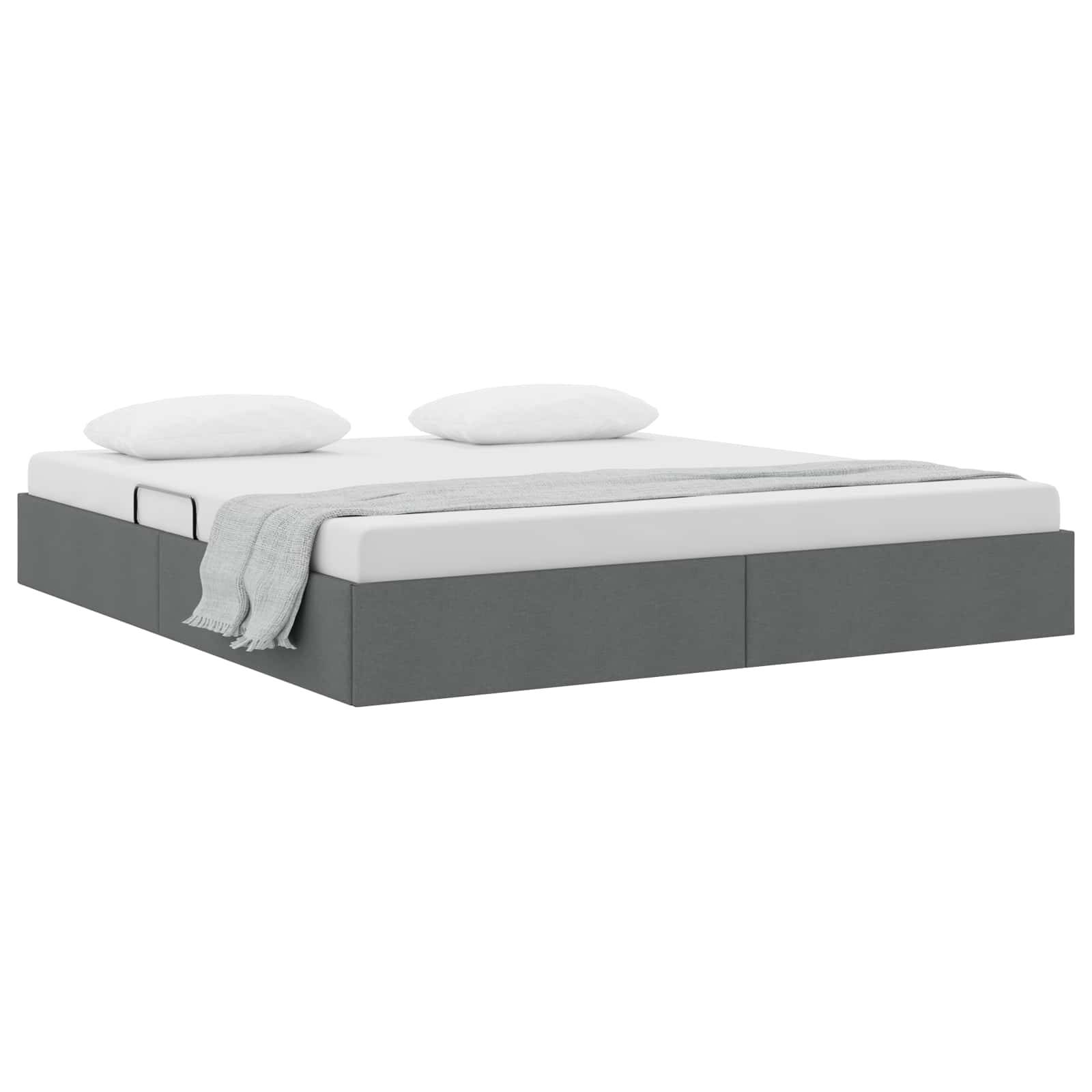 Graupolsteriertes Bett mit zwei weißen Kissen und einer leichten Wurfdecke auf weißem Hintergrund.