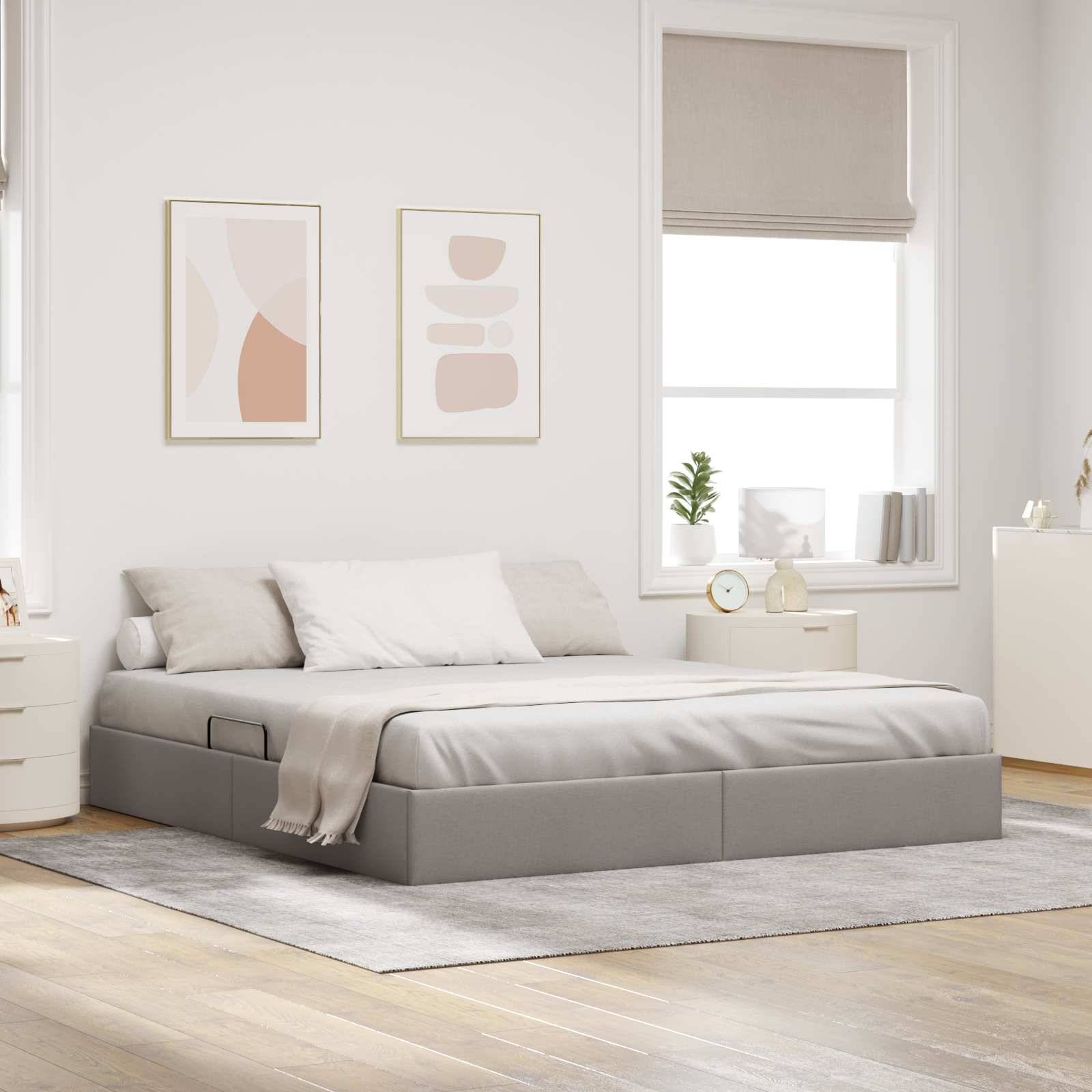 Modernes Schlafzimmer mit einem niedrigen grauen Bett, neutraler Bettwäsche, eingerahmten Wandbildern, Fenster mit Jalousie, Nachttisch und hellem Holzfußboden.