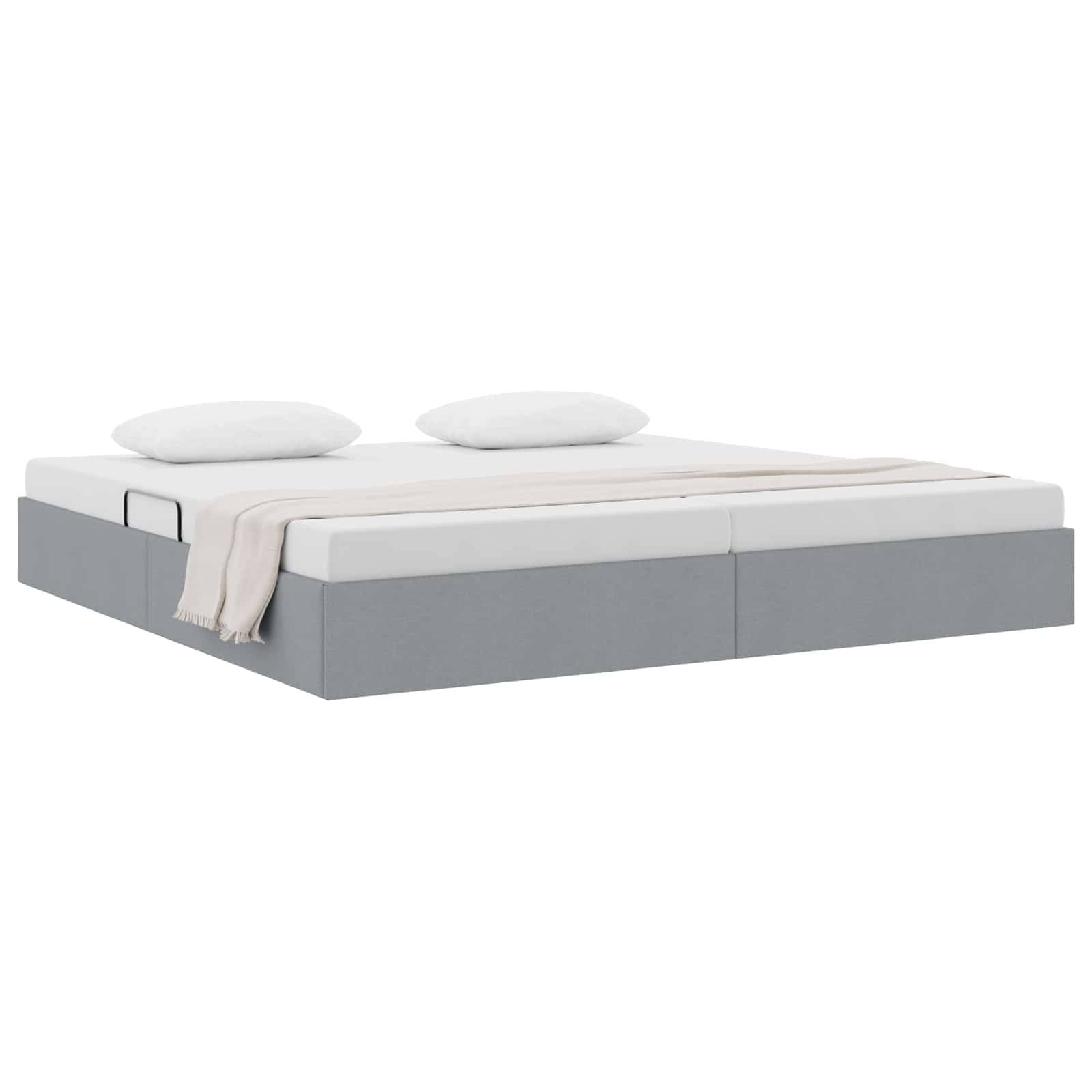 Grau gepolstertes Bett mit Matratze, zwei Kissen und einer drapierten Decke auf weißem Hintergrund.