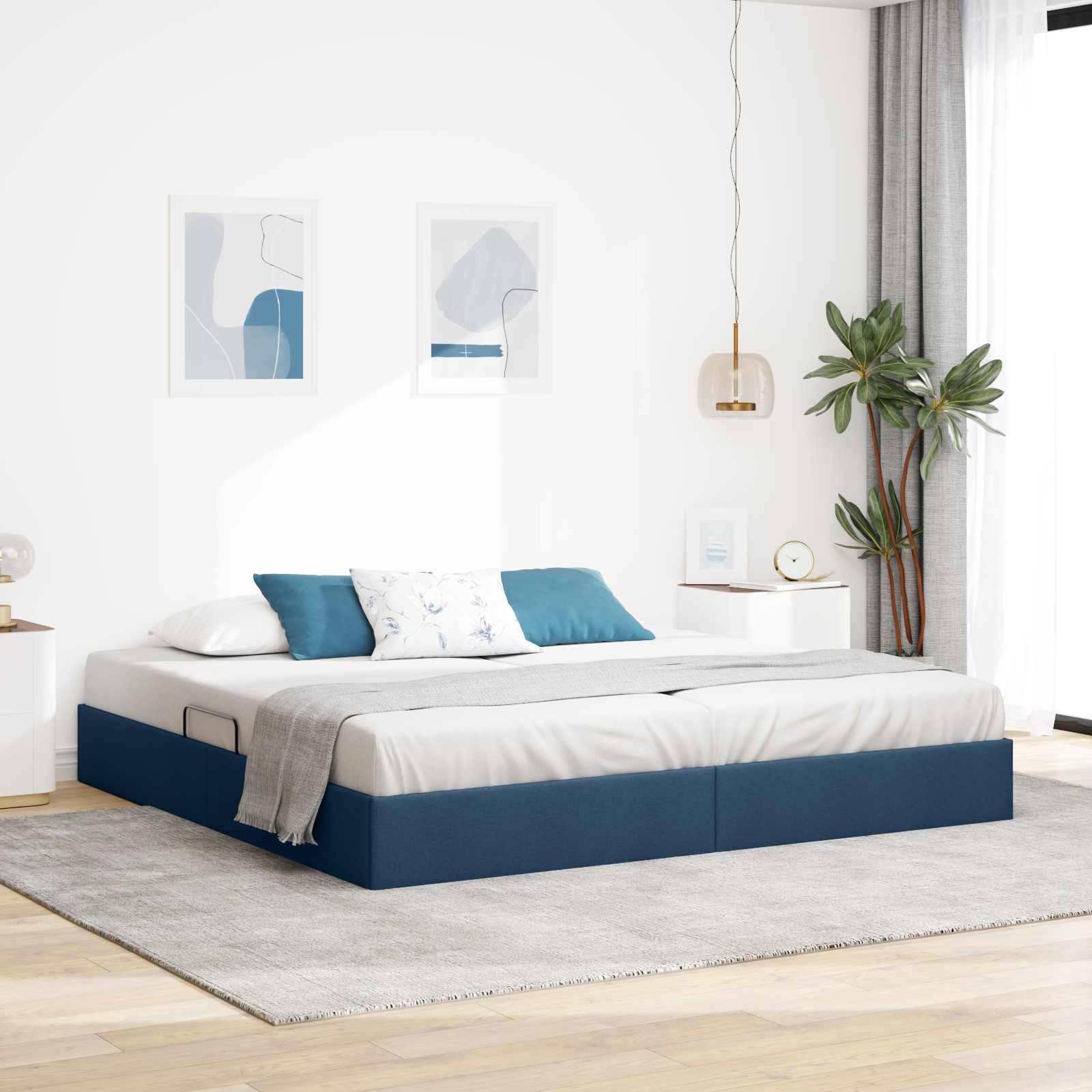 Modernes Schlafzimmer mit einem blaupolsterten Plattformbett, weißer Bettwäsche, grauem Teppich, Wandkunst, Nachttischen, hängender Lampe und Zimmerpflanze.