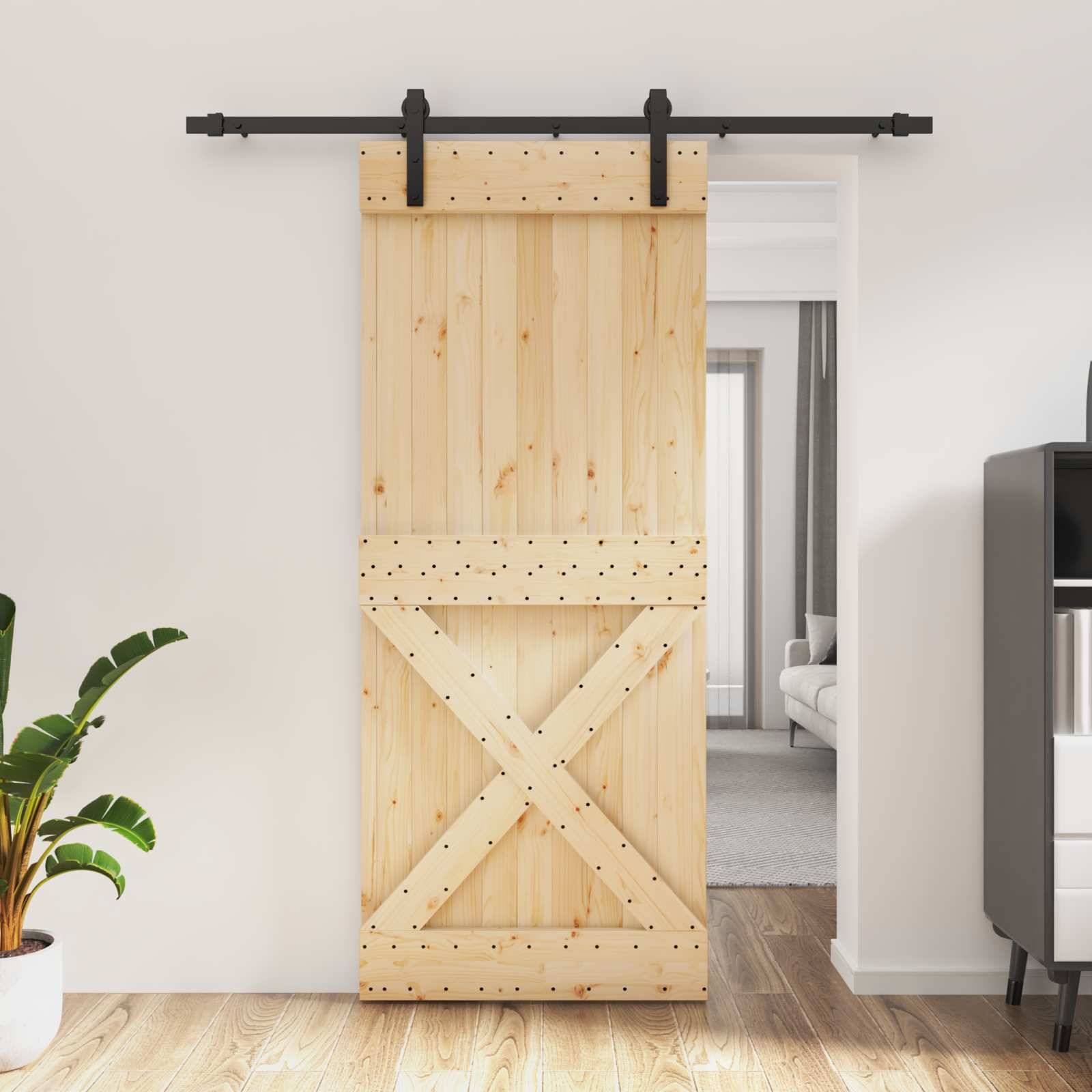 Holzschiebescheunentür mit schwarzem Gleitschienensystem und X-Verband, die halb offen zu einem hellen Raum dahinter führt.