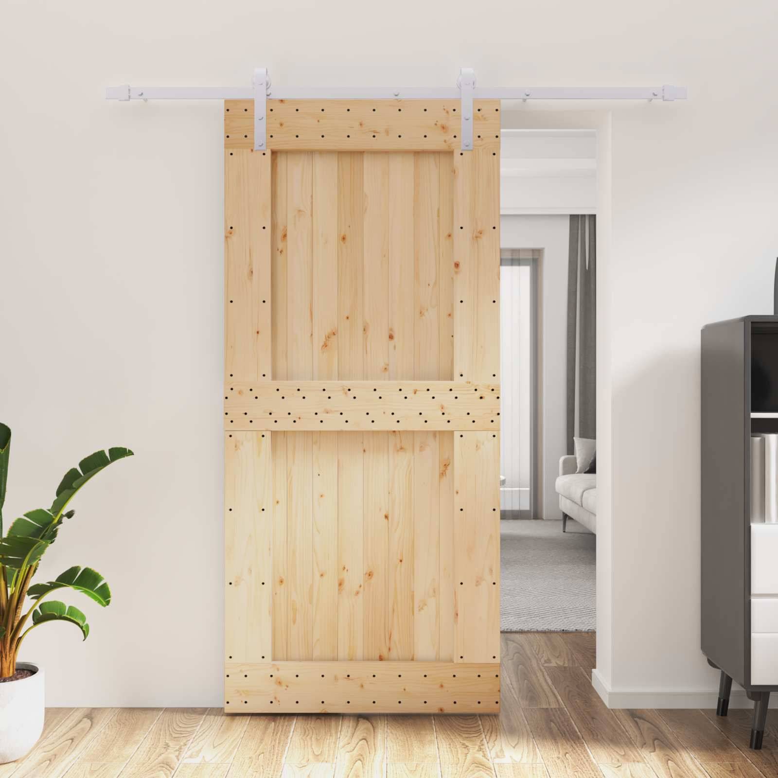 Holztür im Scheunen-Stil mit Schiebemechanismus, an einer weißen Wand montiert, teilweise offen, um einen Raum dahinter zu enthüllen.