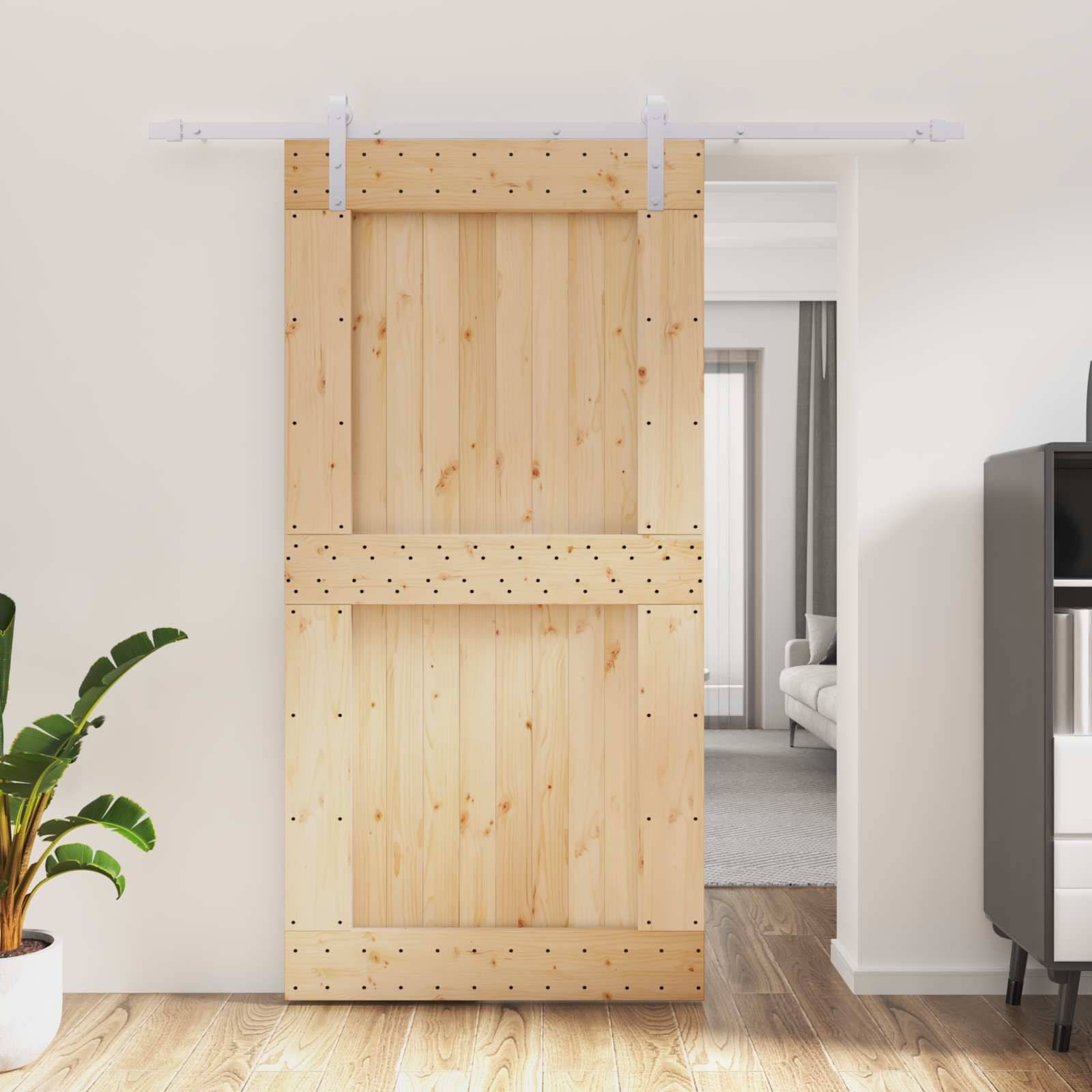Schiebbare Holzscheunentür teilweise offen, die ein helles Wohnzimmer dahinter enthüllt.