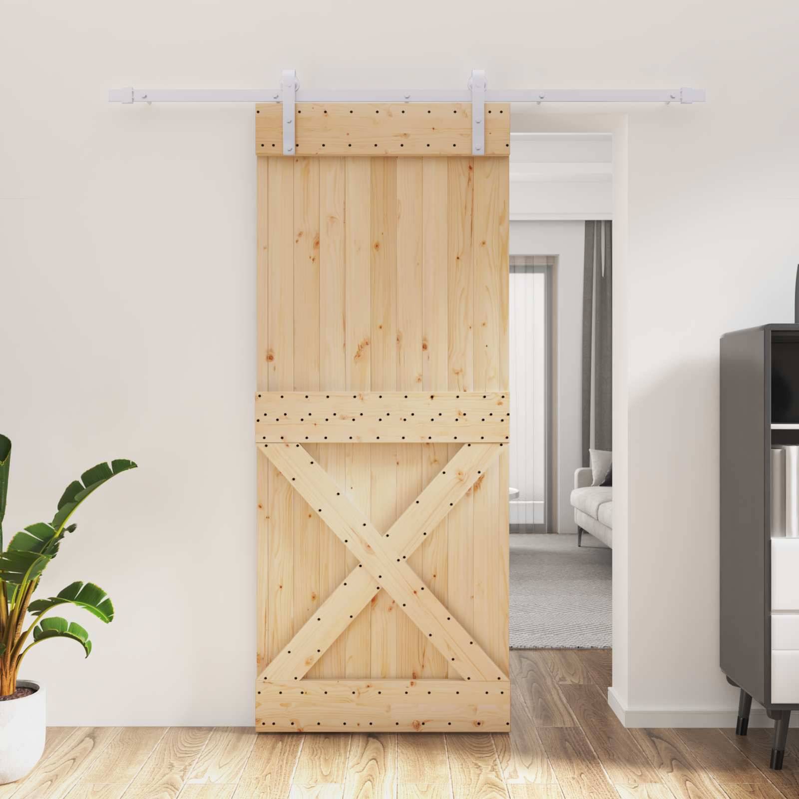 Holzschiebescheunentür mit X-Streben-Beschlag verdeckt teilweise eine Türöffnung zwischen einem hellen Raum und einem Schlafzimmer.