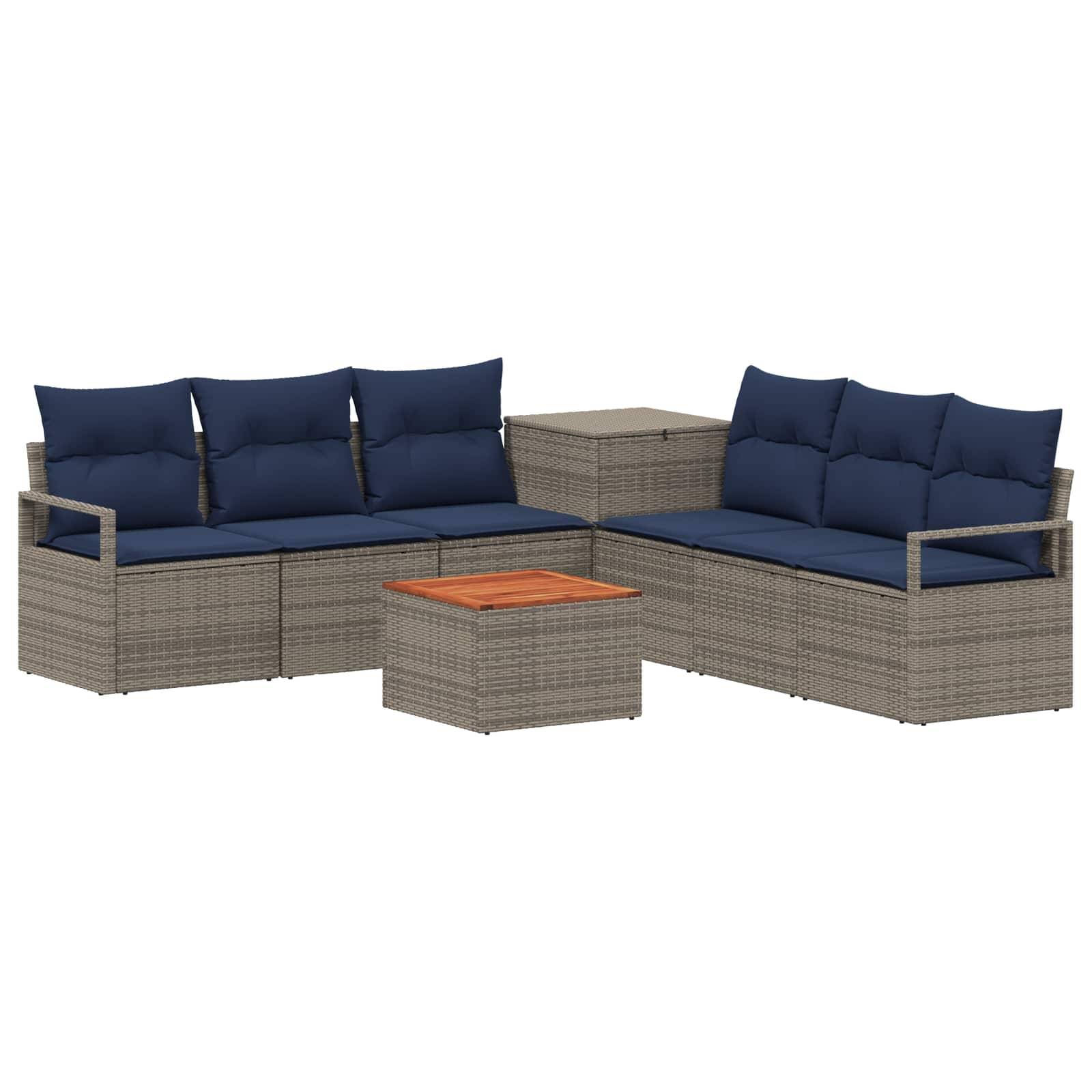 Outdoor-Rattangarnitur für die Terrasse mit marineblauen Kissen, zwei Sofas, einem quadratischen Beistelltisch und einem kleinen Couchtisch mit Holzplatte.
