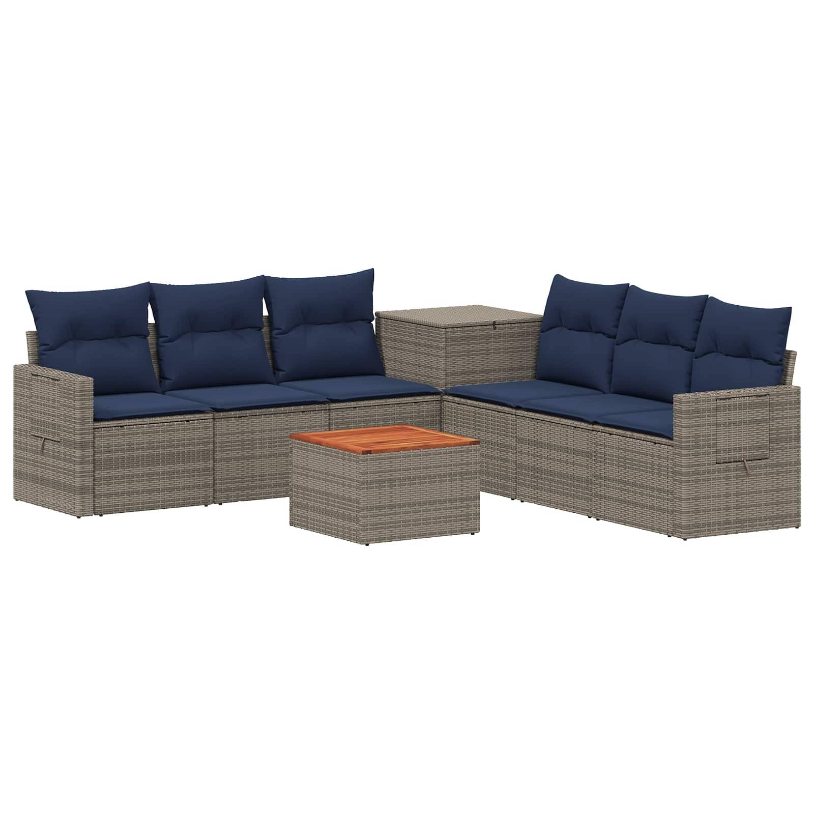 Outdoor-Rattangarnitur mit Sektional, marineblauen Kissen, passendem Beistelltisch und kleinem quadratischem Couchtisch mit Holzplatte.