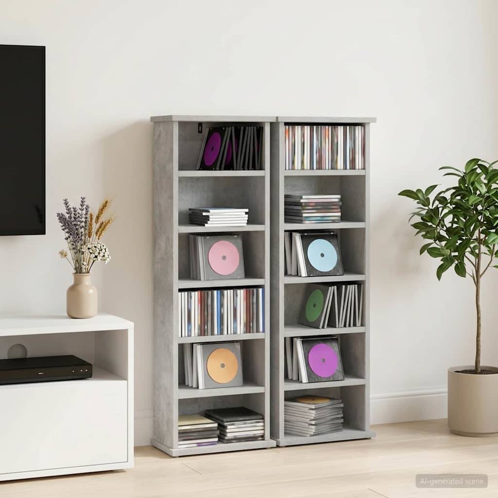 Zwei graue Regale voller Schallplatten und CDs stehen in einem minimalistischen Zimmer neben einem Fernseher, Schrank, getrockneten Blumen und einer Topfpflanze.