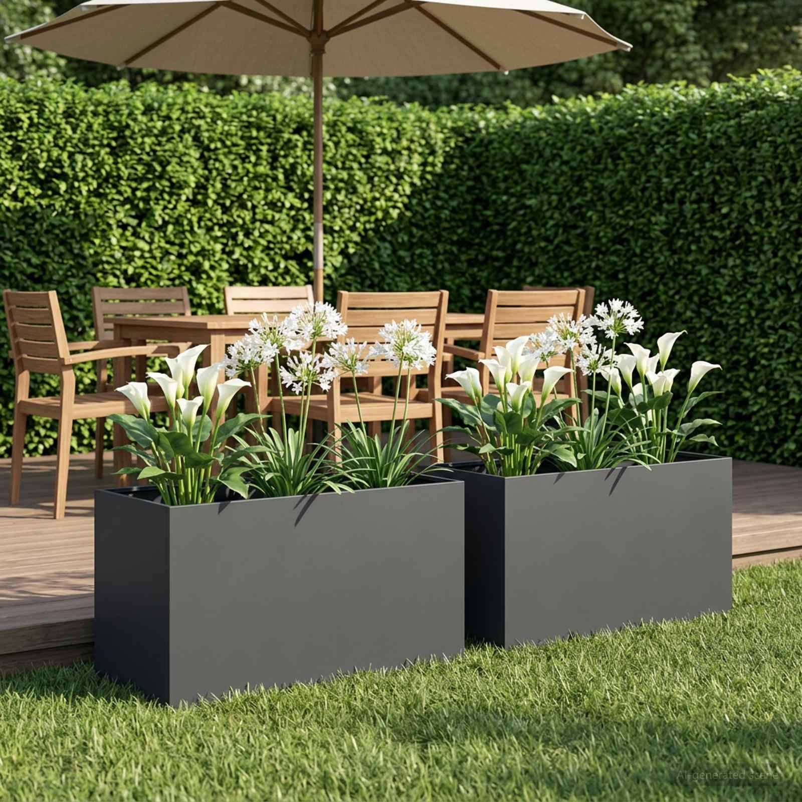 Terrasse im Freien mit Holzesspgruppe unter einem Sonnenschirm, eingerahmt von zwei schwarzen Pflanzgefäßen gefüllt mit weißen Blüten und grünem Laub.