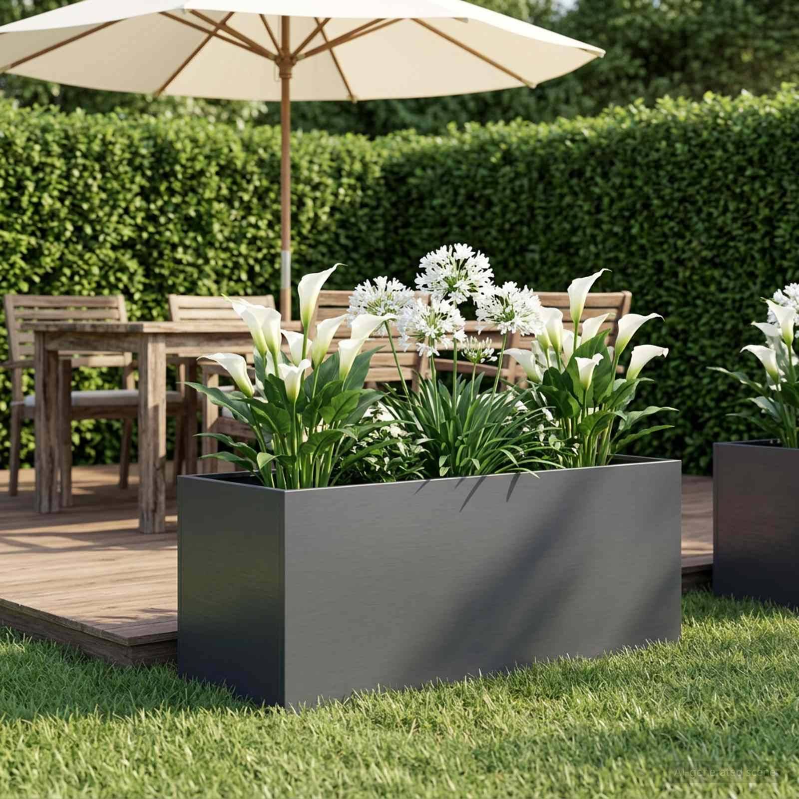 Moderne Terrasse mit einem großen rechteckigen Pflanzgefäß mit weißen Blumen und grünen Blättern, auf einer Holzterrasse neben einem Außentisch und einem Sonnenschirm angeordnet.