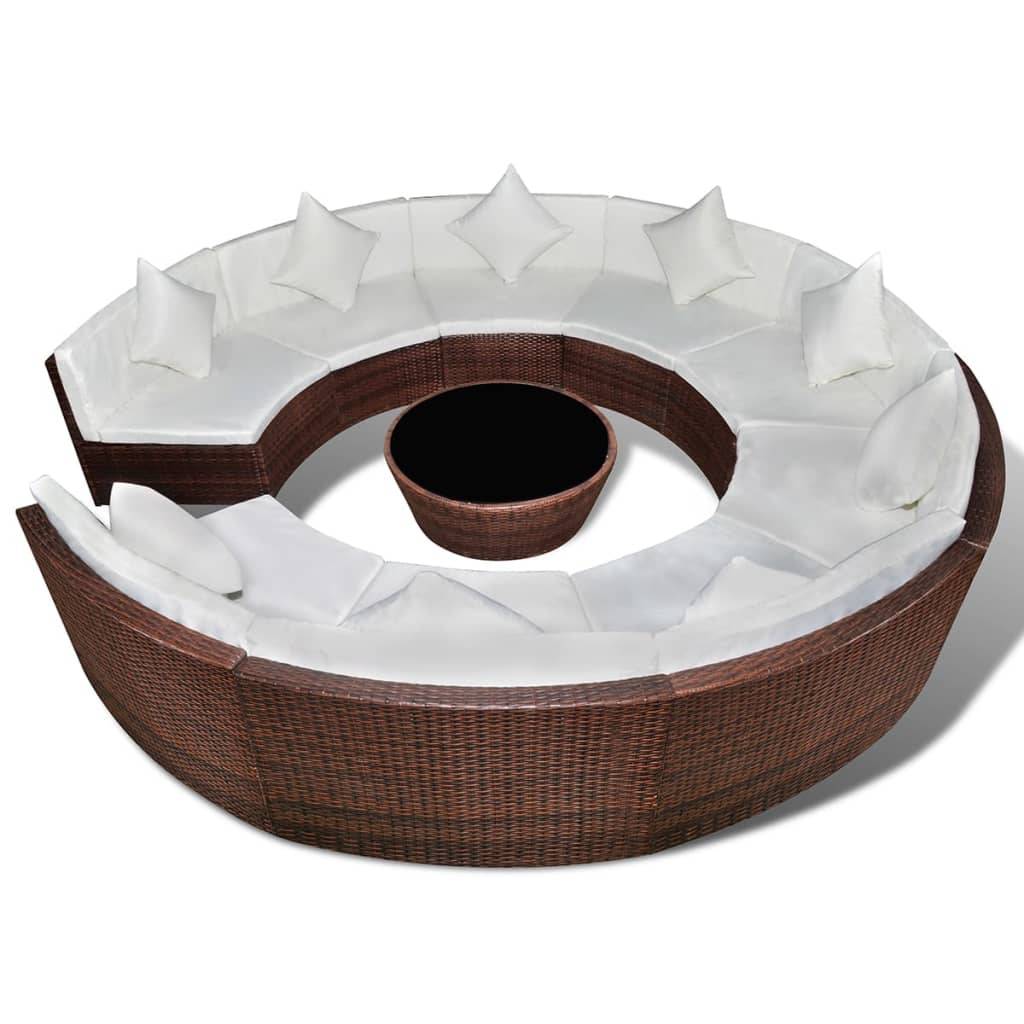 Rundes Outdoor-Rattansektionalsofa mit weißen Kissen und passendem rundem Couchtisch in der Mitte.