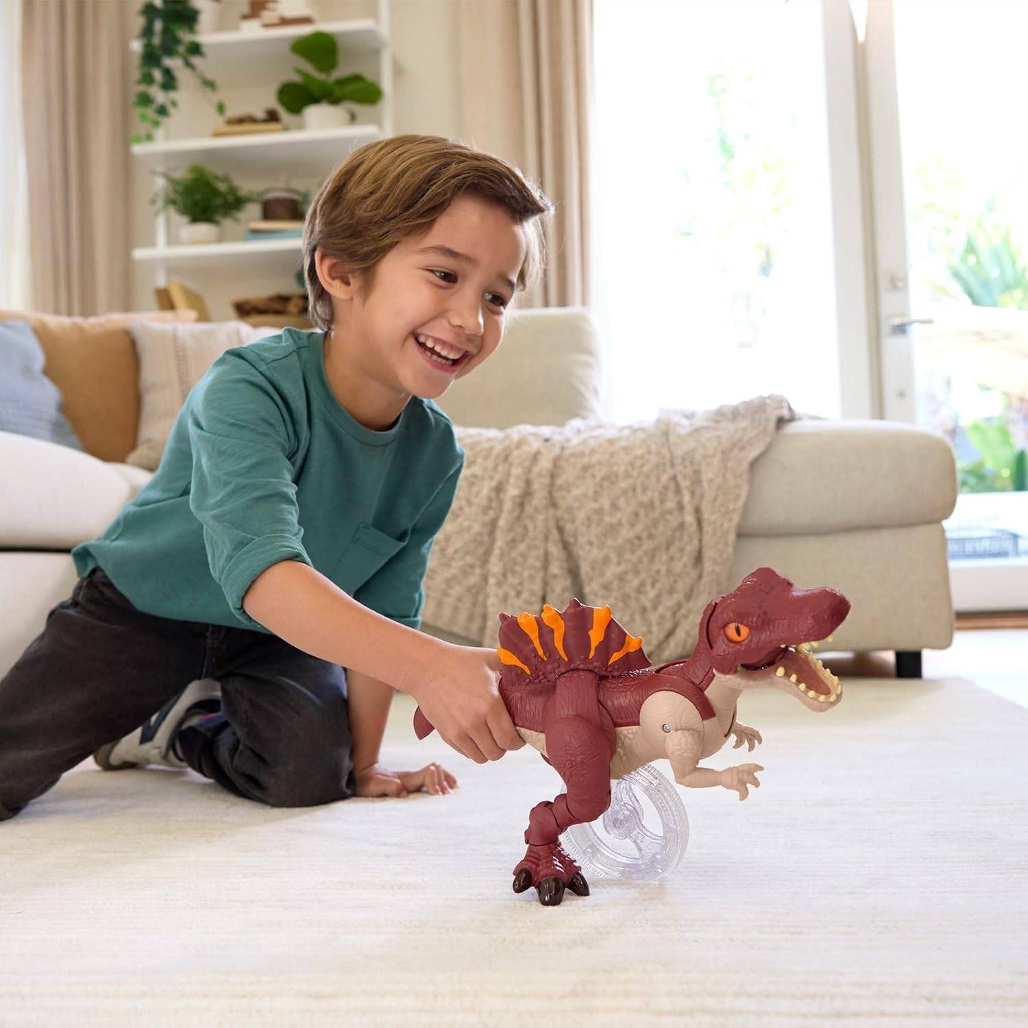 Ein lächelndes Kind kniet auf dem Boden und spielt mit einem Spielzeug-Dinosaurier in einem hellen Wohnzimmer.
