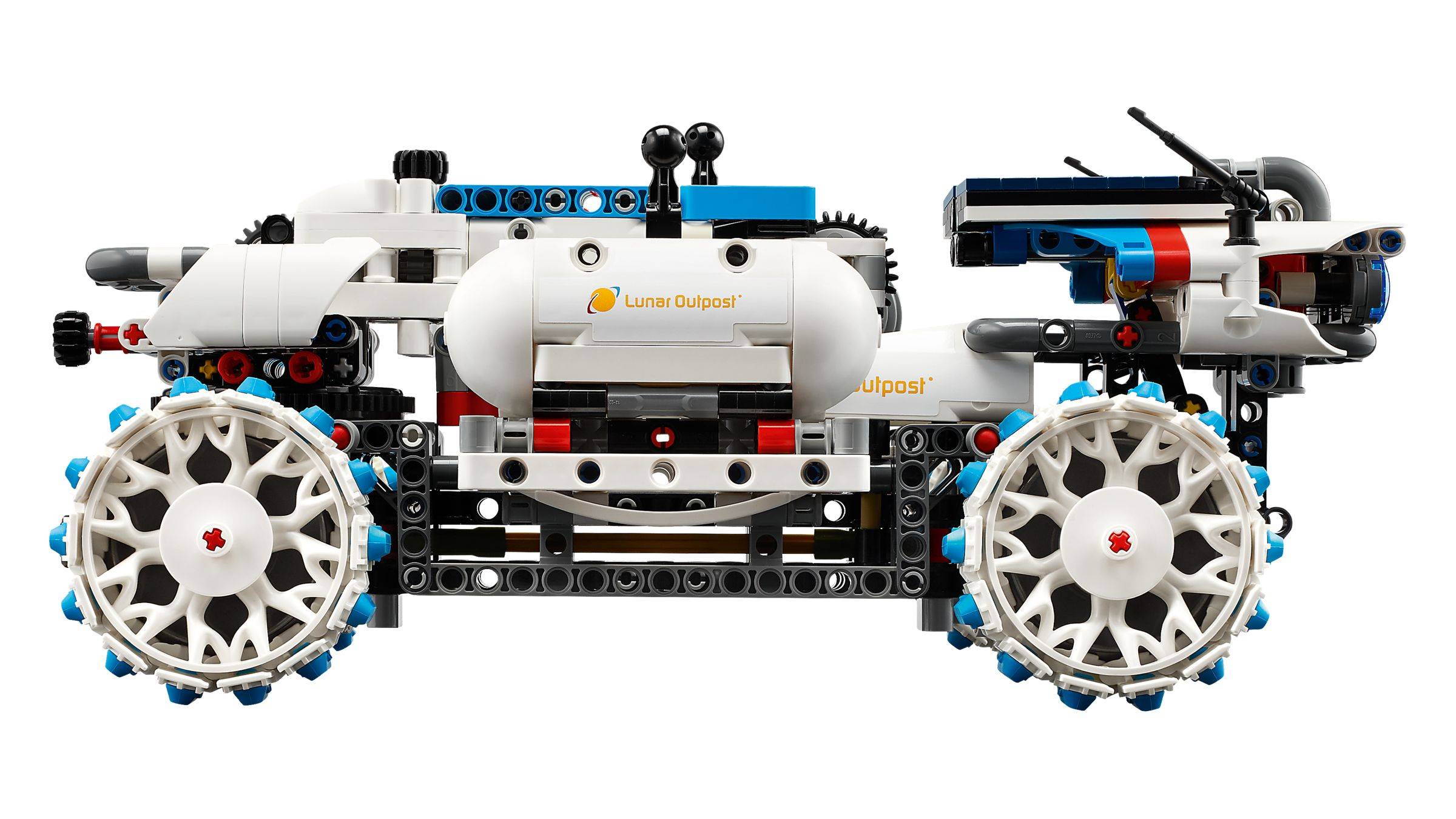 Seitenansicht eines LEGO Technic-ähnlichen Offroad-Fahrzeugfahrgestells mit großen weißen Rädern, weißem Tankgehäuse und freiliegenden blau-schwarzen mechanischen Teilen auf weißem Hintergrund.