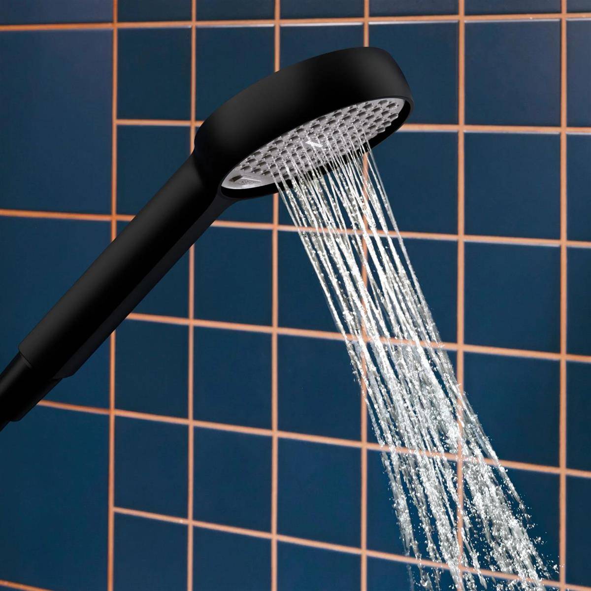 Schwarzer tragbarer Duschkopf, der Wasser gegen eine blaue Fliesenwand sprüht.