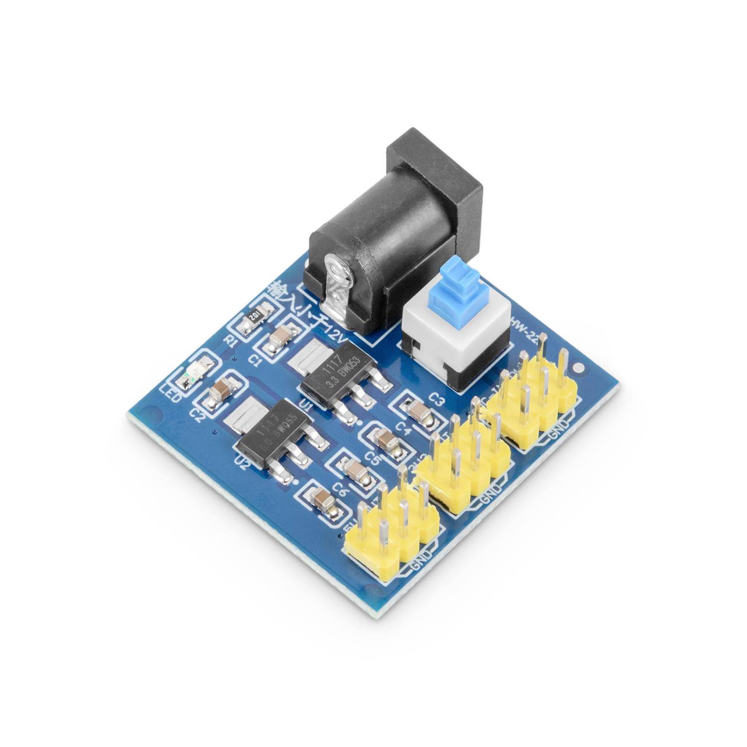 Kleine blaue elektronische Breakout-Platine mit DC-Stromstecker, Druckknopf und gelben Stiftleisten für Schaltungsverbindungen.
