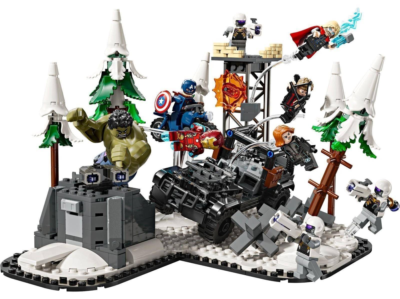 LEGO-Superhelden-Kampfszene mit Hulk, der eine graue Festung zerschmettert, Captain America und Black Widow kämpfen gegen Feinde um ein zerstörtes schwarzes Fahrzeug in einem schneebedeckten Wald.
