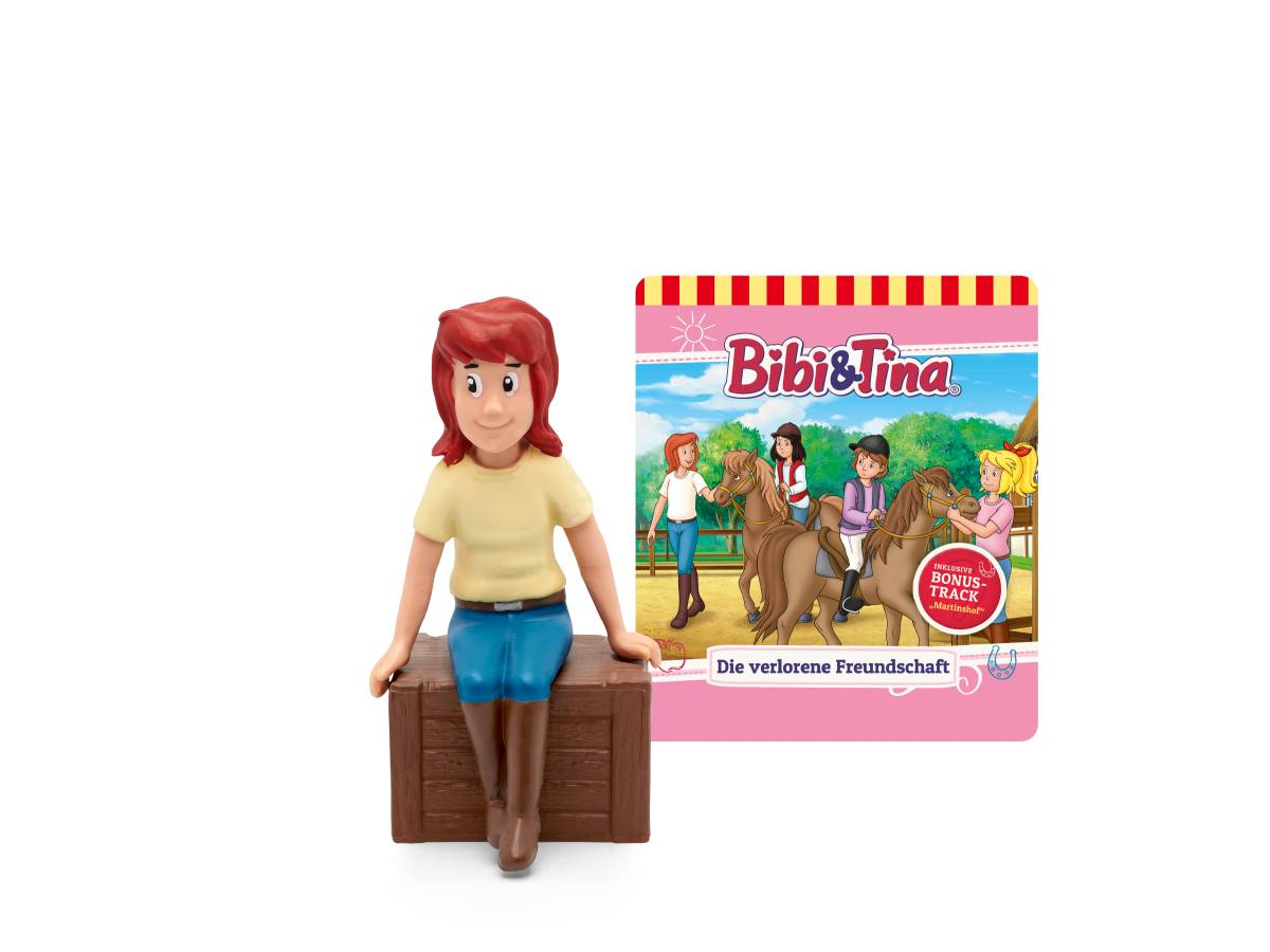 Bibi Blocksberg Figur sitzt auf einer Holzkiste neben einem „Bibi & Tina