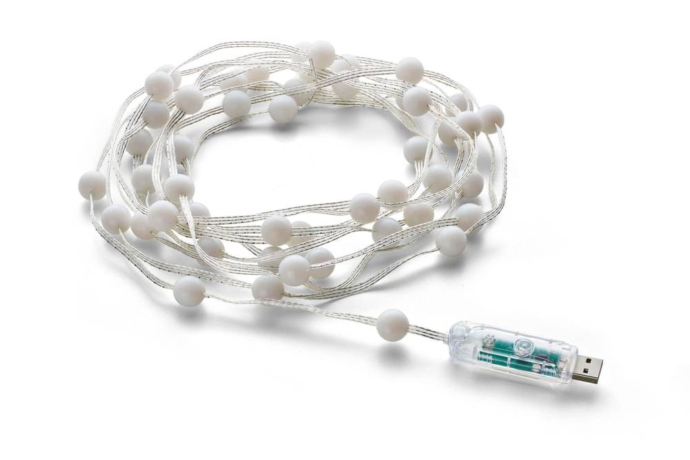 Aufgerollte Lichterkette mit weißen runden Glühbirnen und USB-Stecker auf weißem Hintergrund.