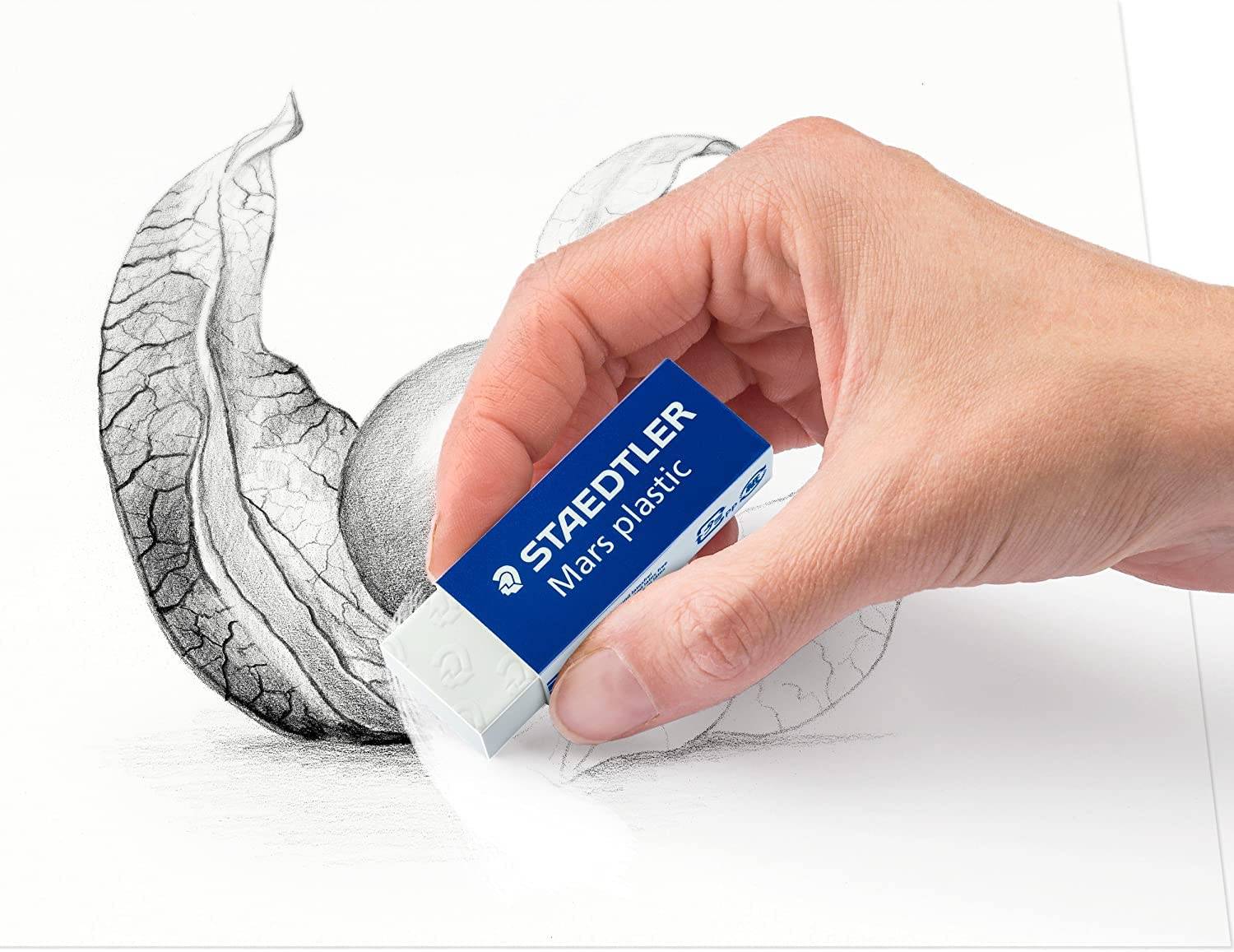 Hand, die einen Staedtler Mars Kunststoffradierer verwendet, um Bleistiftschatten auf einem gezeichneten gekrümmten Objekt auf einem weißen Blatt zu entfernen oder zu verfeinern.