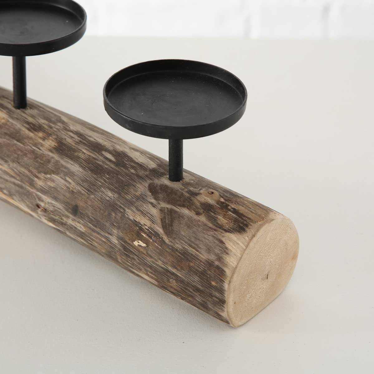 Rustikaler Kerzenhalter aus Holzstämmen mit zwei schwarzen Metallschalen für Teelichter auf einer verwitterten Holzbasis