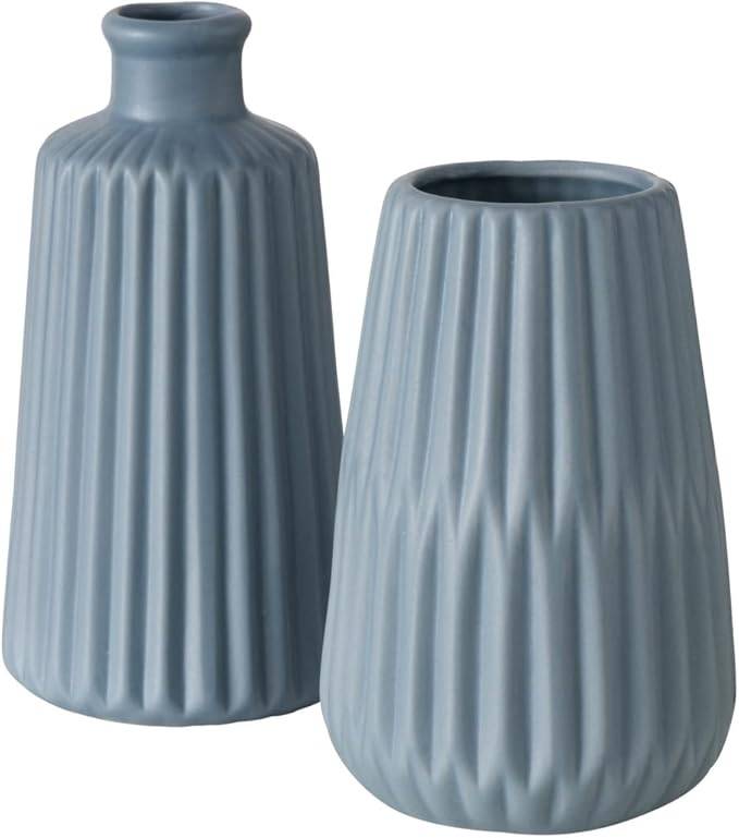 Zwei hellblaue gerippte Keramikvasen, eine hohe mit schmalem Hals und eine kürzere, breitere Vase, auf weißem Hintergrund gezeigt.