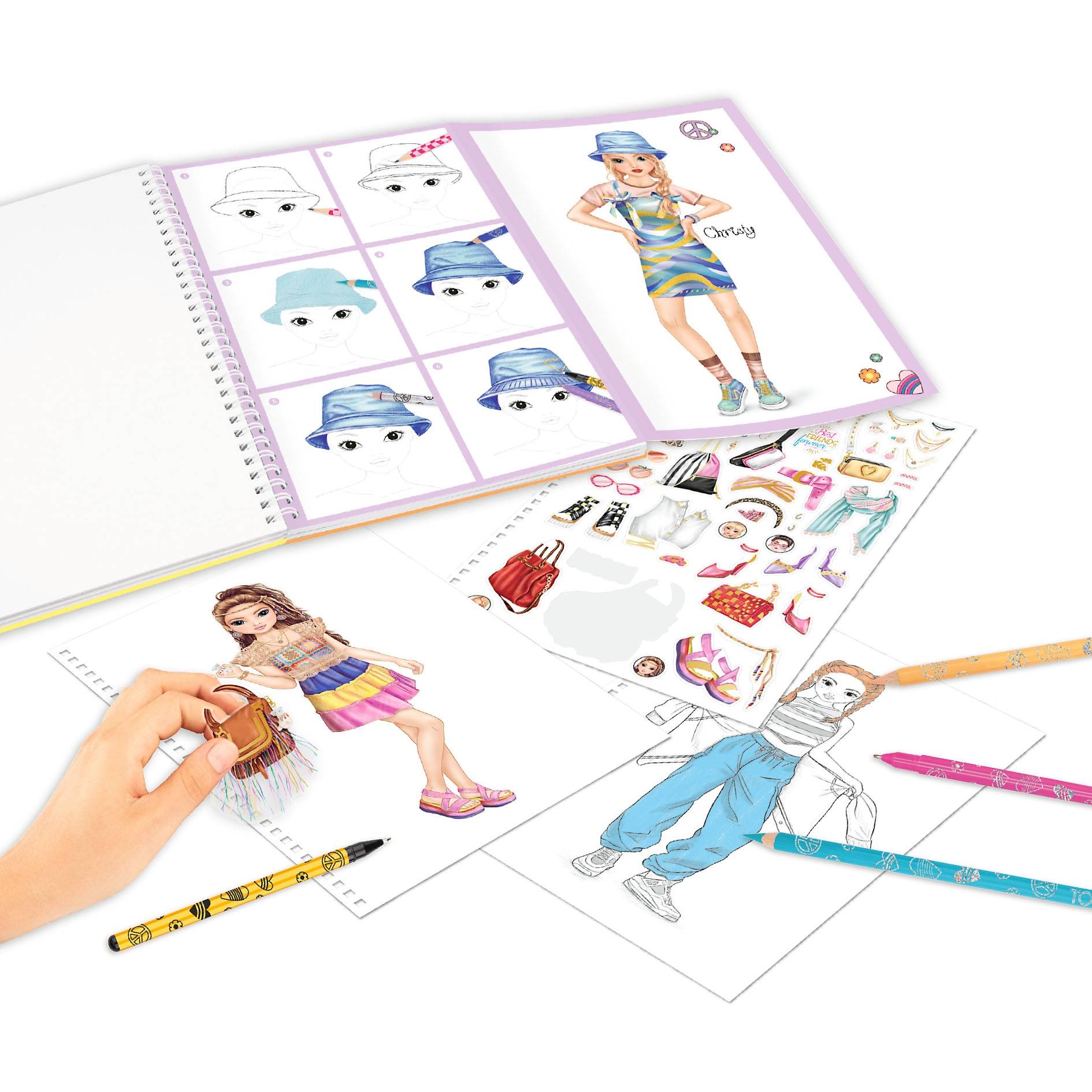 Modedesign-Aktivität mit einem Skizzenbuch voller Outfit- und Hutideen, ein Kind, das eine Papierpuppe ausmalt, und verstreute Buntstifte, Marker und Accessoires.