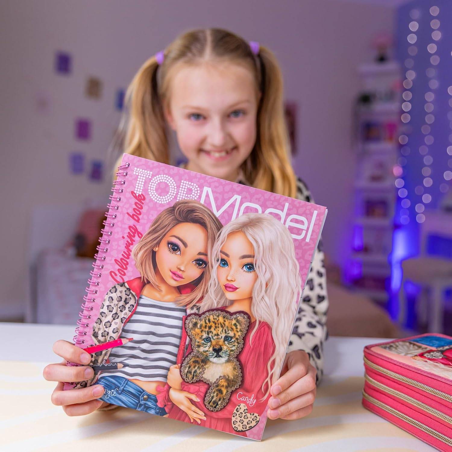 Lächelndes Mädchen hält ein rosa „TOPModel