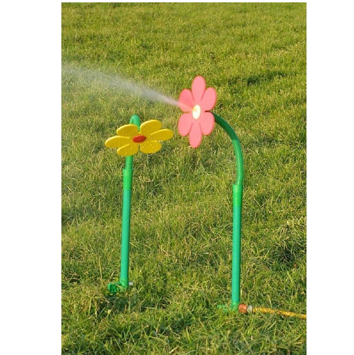 Zwei blumenförmige Gartensprinkler auf einem Rasen sprühen Wasser, einer rosa und einer gelb.