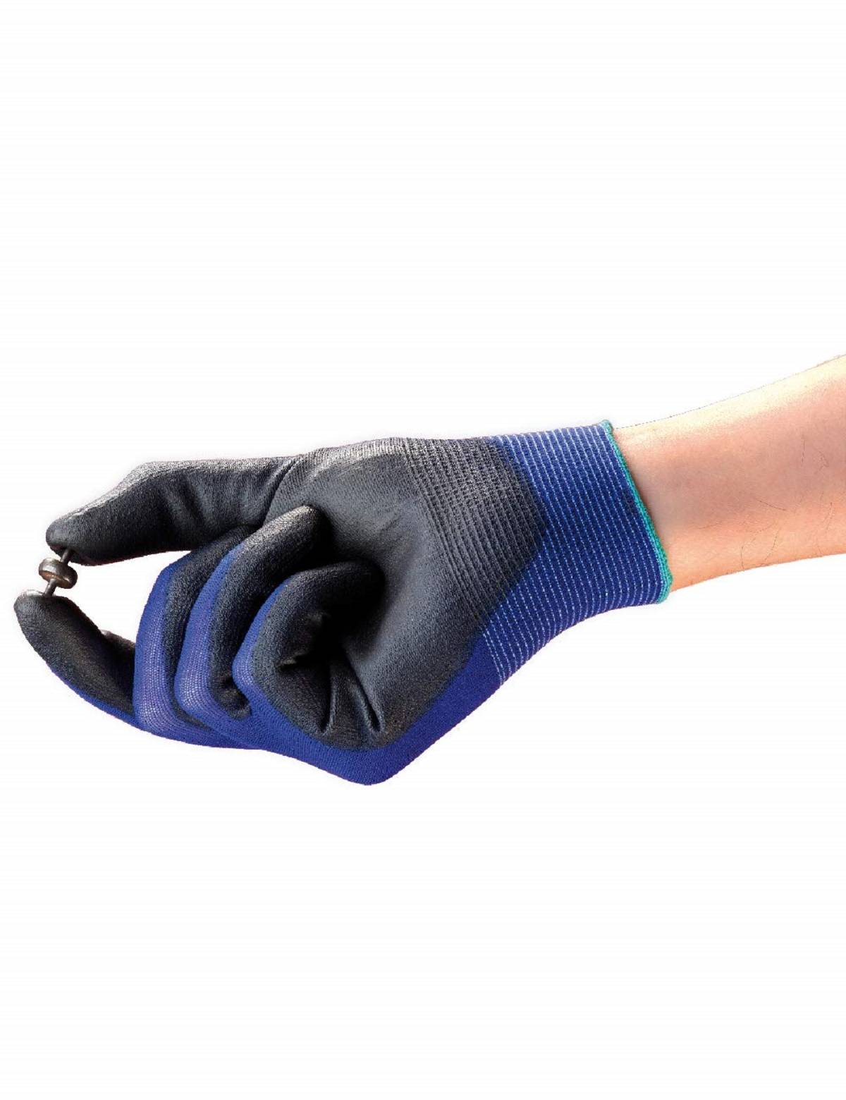 Hand in schwarzem und blauem Arbeitshandschuh hält einen kleinen Metallring vor weißem Hintergrund.