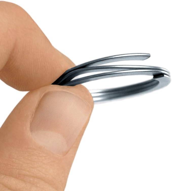 Nahaufnahme von Fingern, die einen kleinen Stapel dünner Metallringe oder Unterlegscheiben halten.