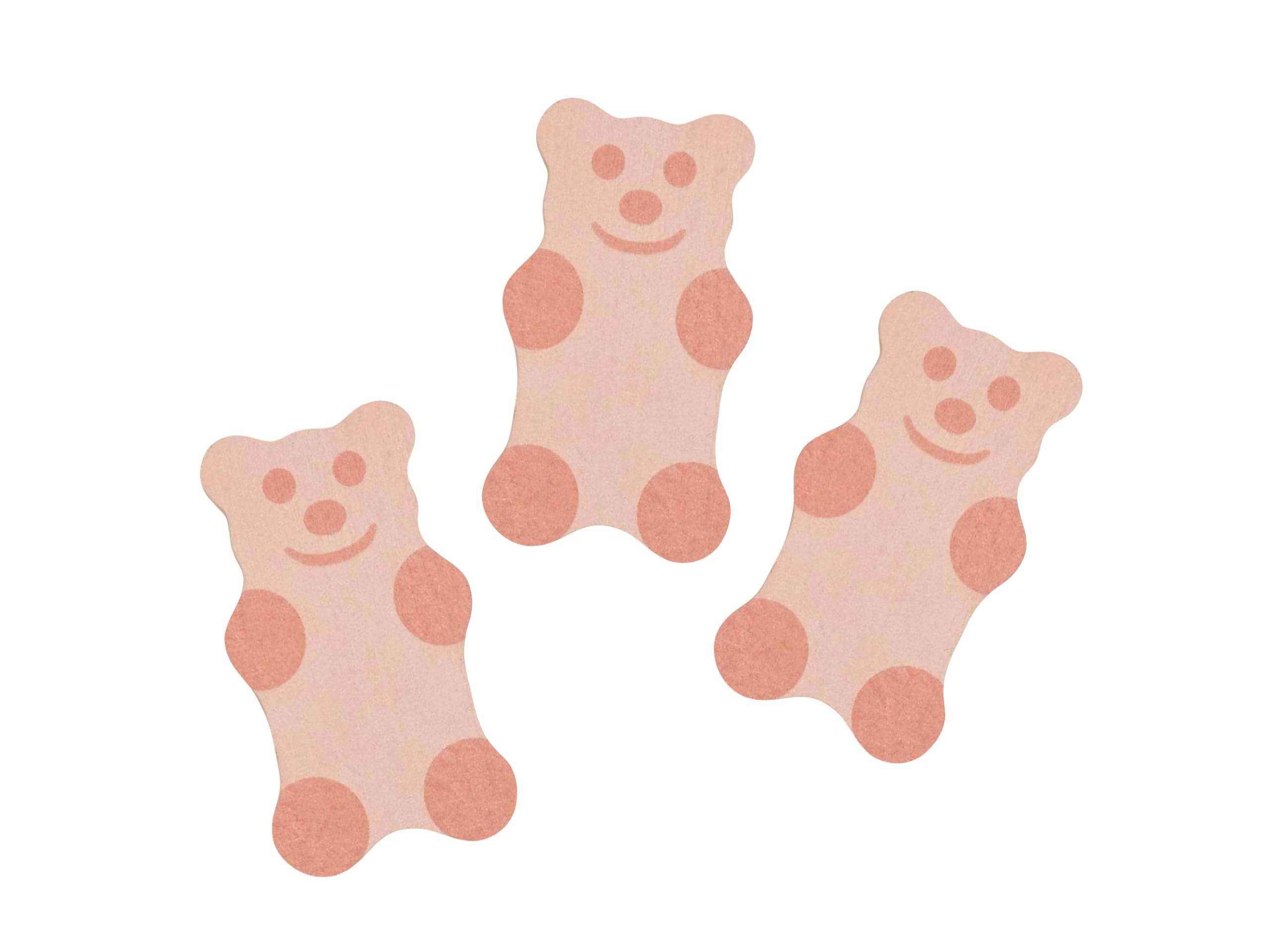 Drei rosa teddybärförmige Kekse oder Süßigkeiten mit lächelnden Gesichtern auf weißem Hintergrund.